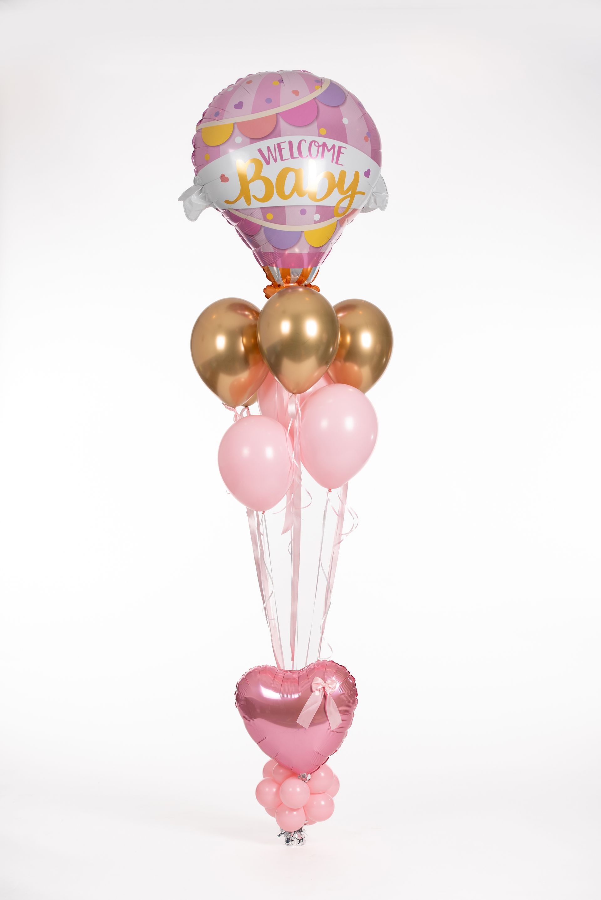 A bunch of pink and gold balloons are sitting on top of each other on a table.
