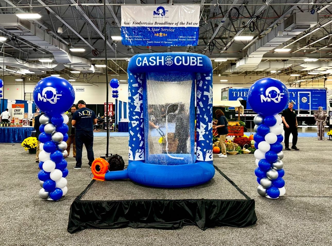 A blue and white cash cube with balloons in a room.
