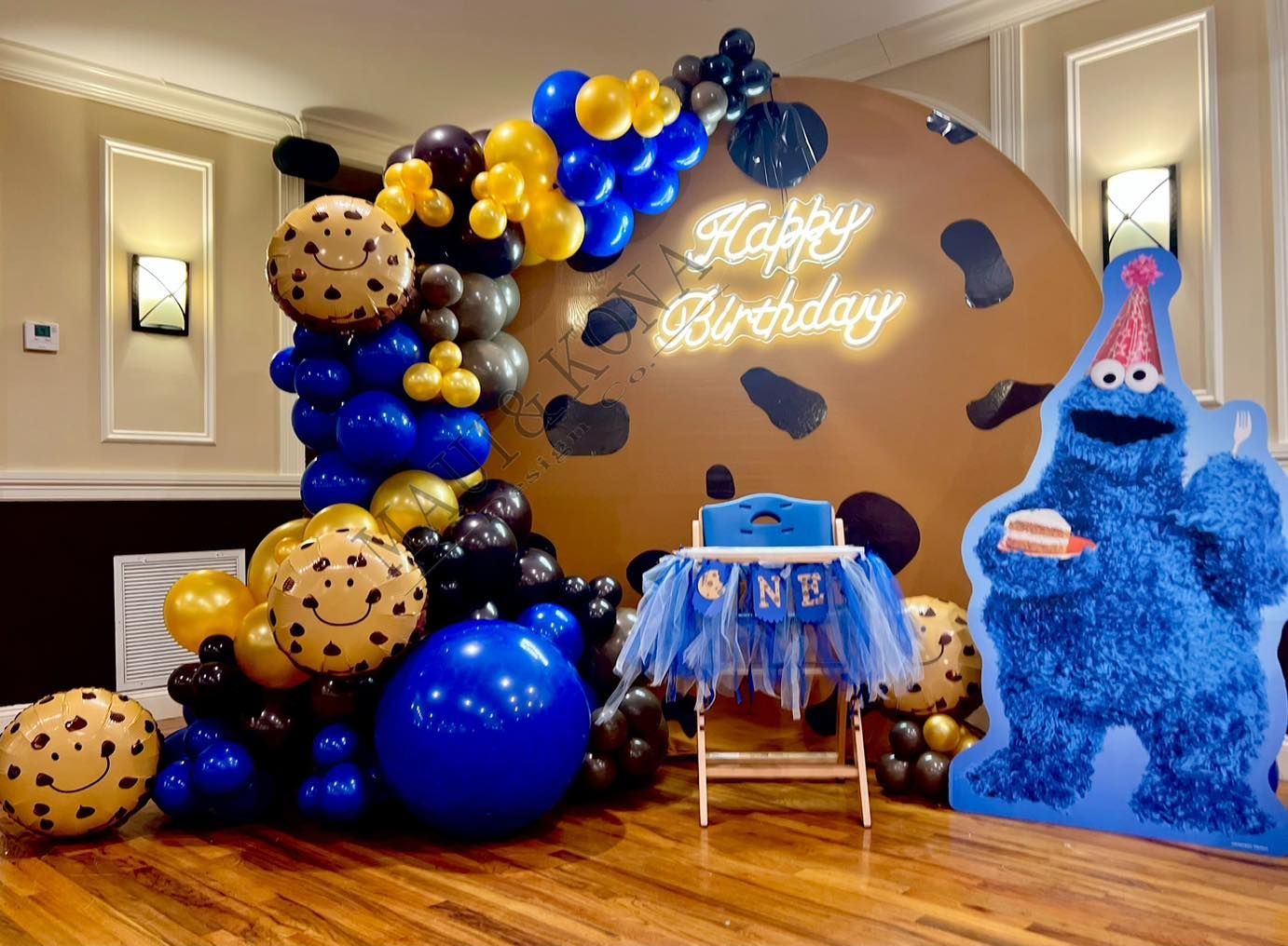 A room decorated with balloons and a cookie monster.