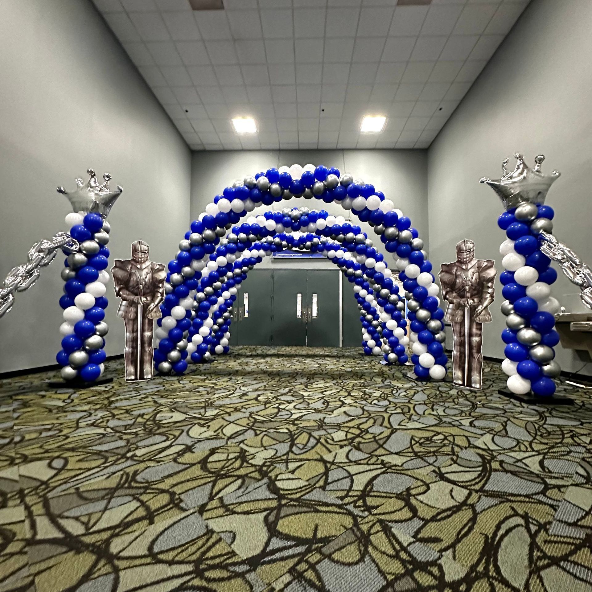 A room filled with blue and silver balloons and statues