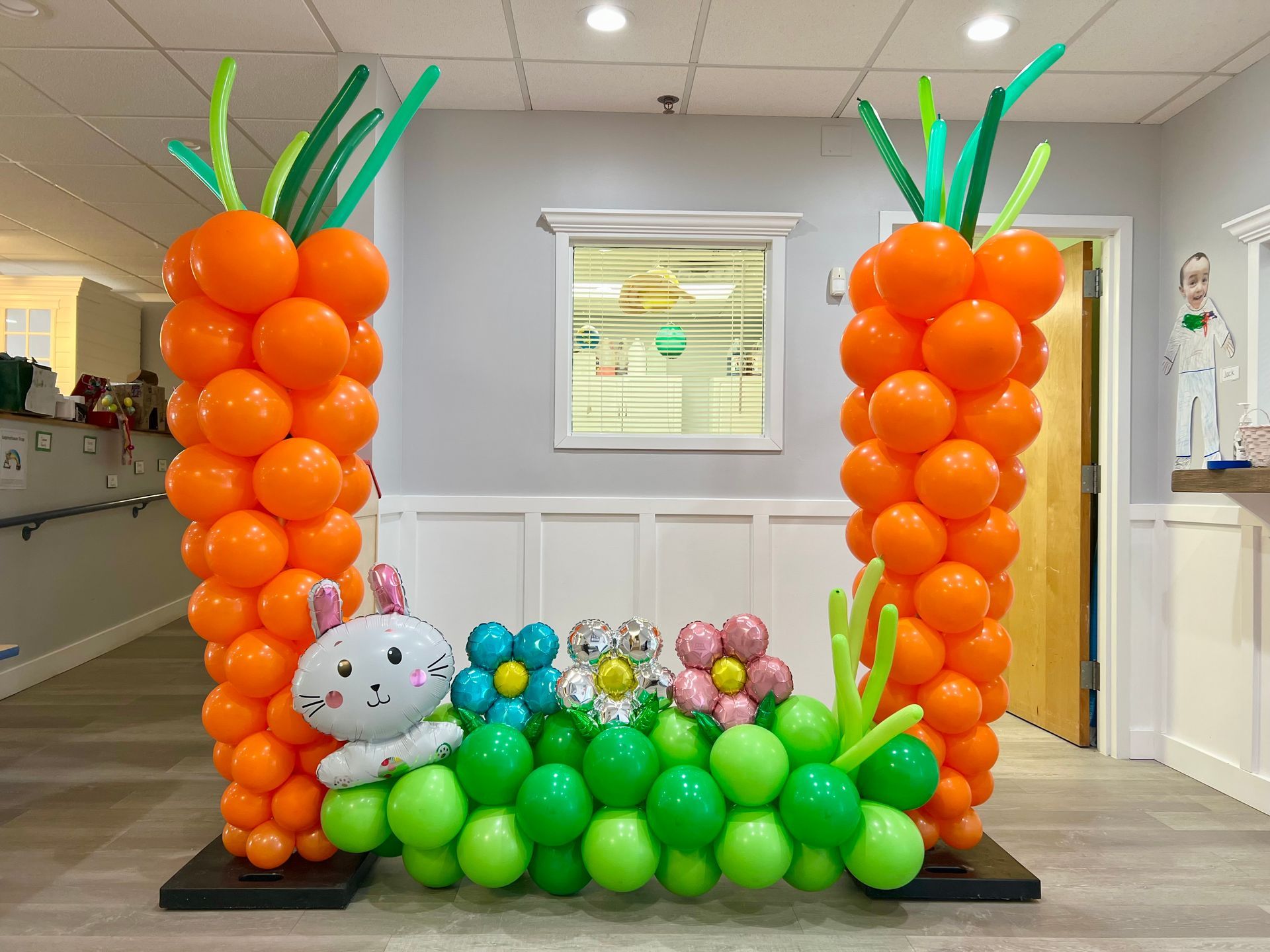 A bunch of balloons are shaped like carrots and flowers.