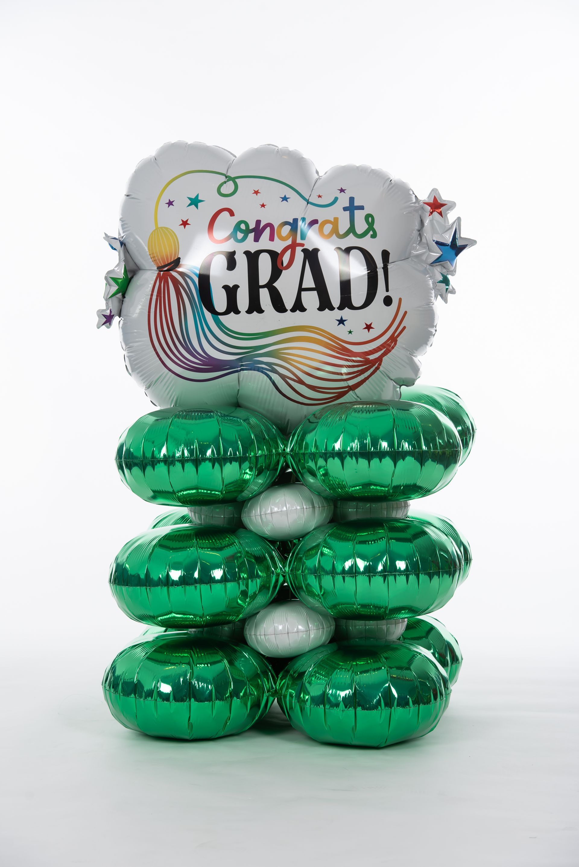 A stack of green and white balloons with a congratulations grad balloon in the middle.