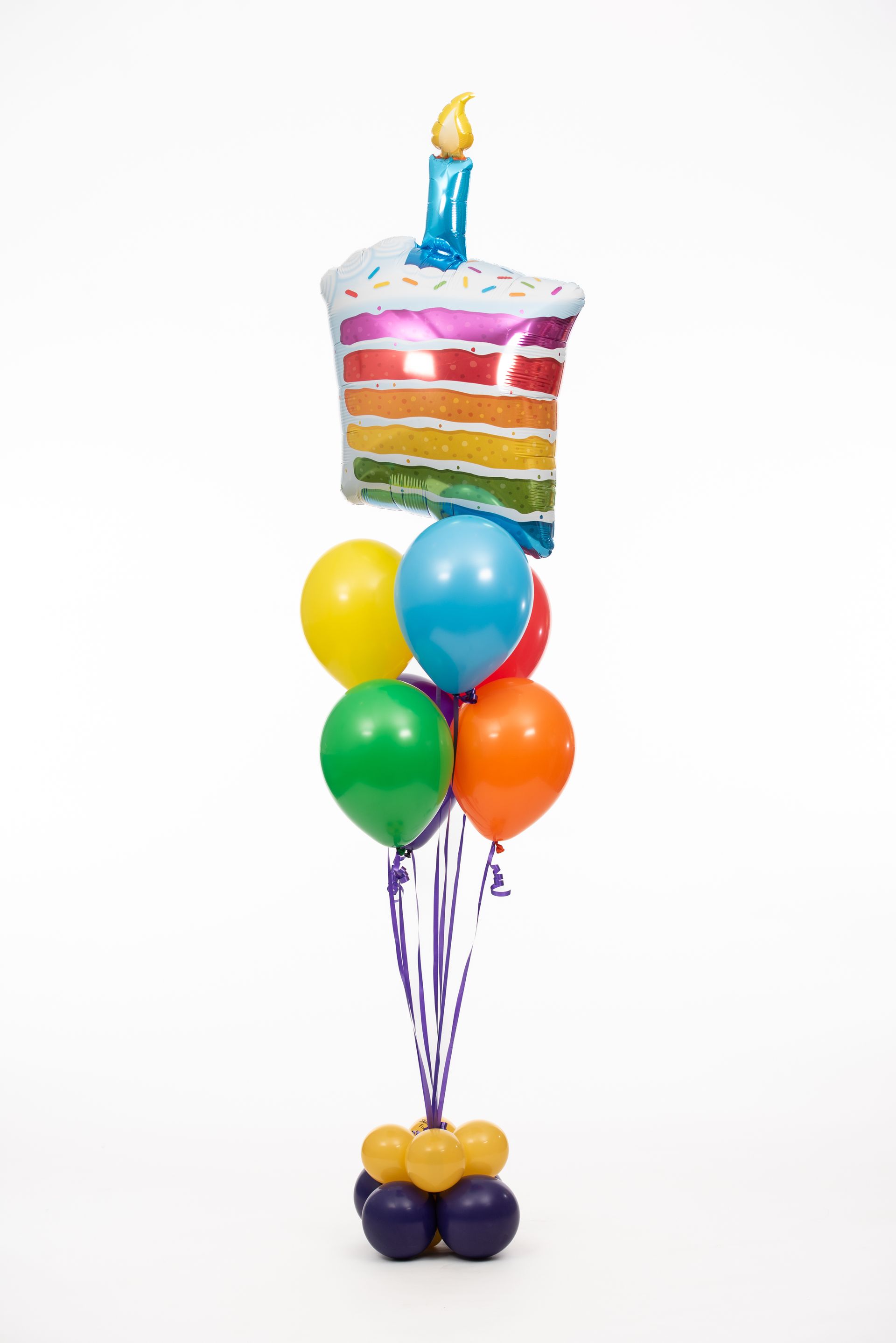 A bunch of balloons with a balloon in the shape of a birthday cake.