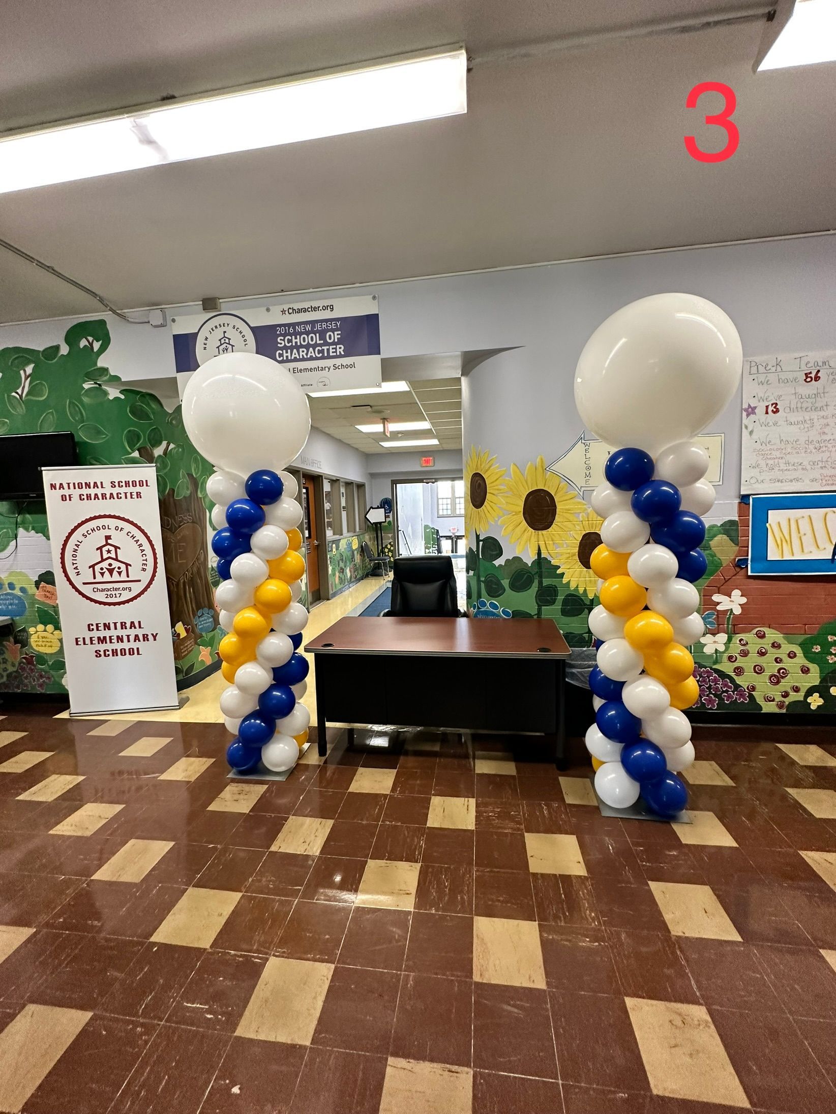 A hallway with balloons and a sign that says 3