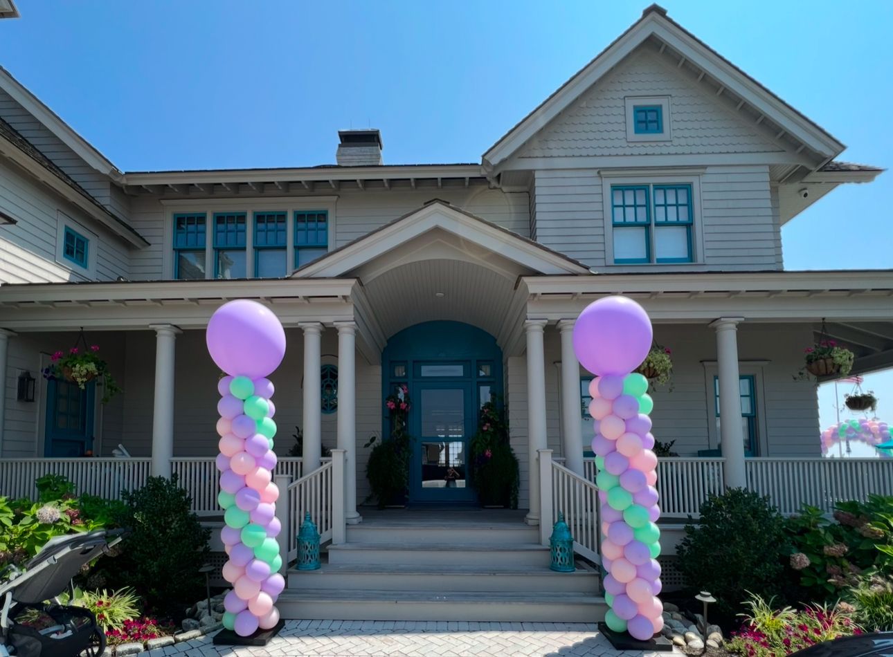 A large white house with balloons in front of it