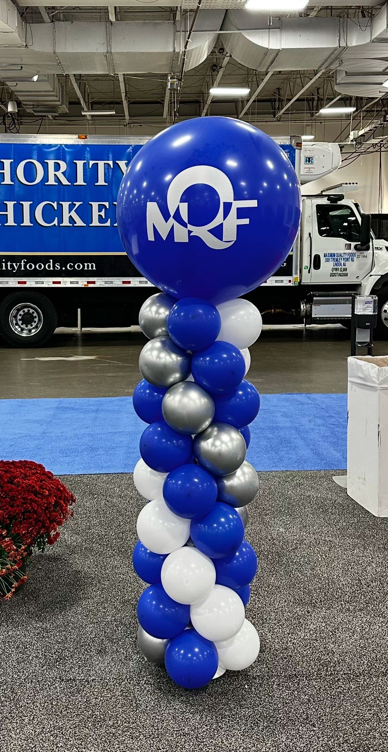 A blue and white balloon display with a truck in the background.