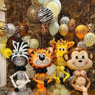 A bunch of balloons in the shape of animals are sitting on a table.