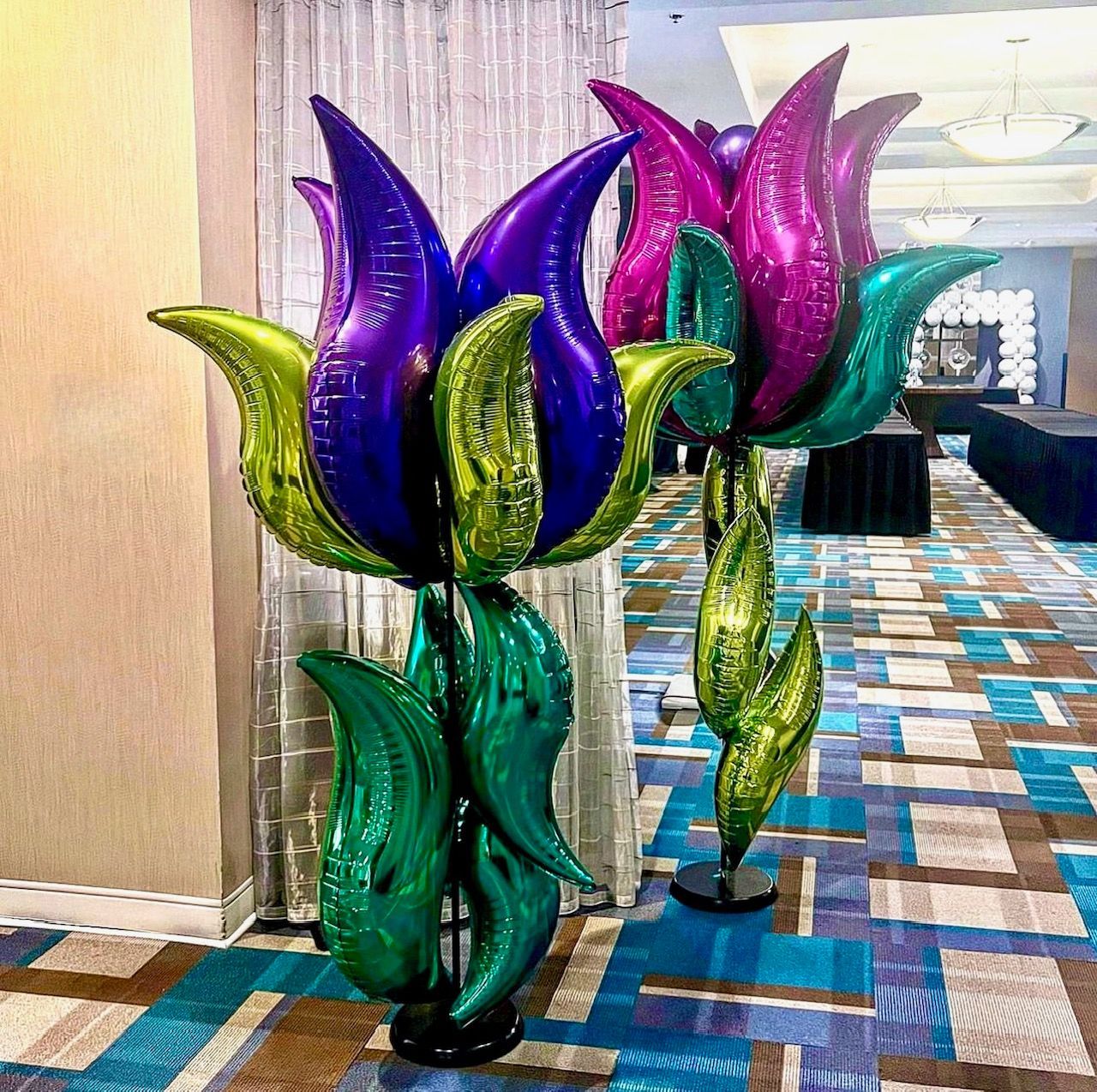 A bunch of balloons shaped like flowers are sitting on a stand in a room.