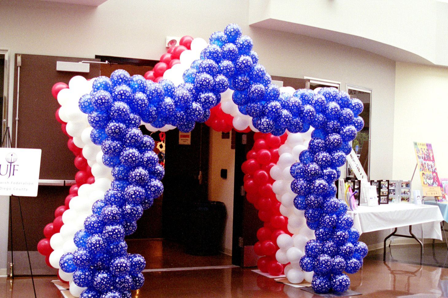 A red white and blue balloon arch in the shape of a star
