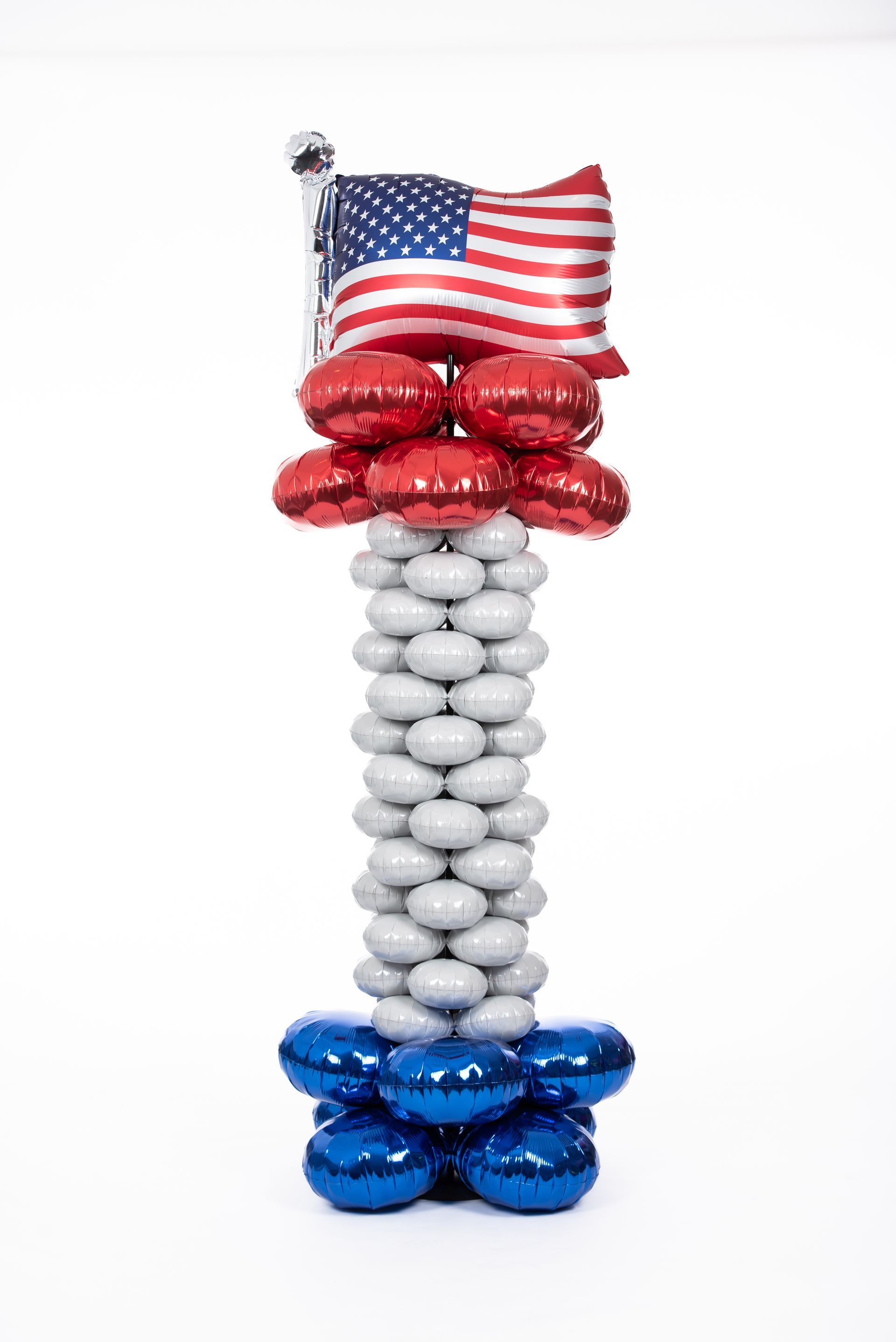 A red , white and blue balloon column with an american flag on top.