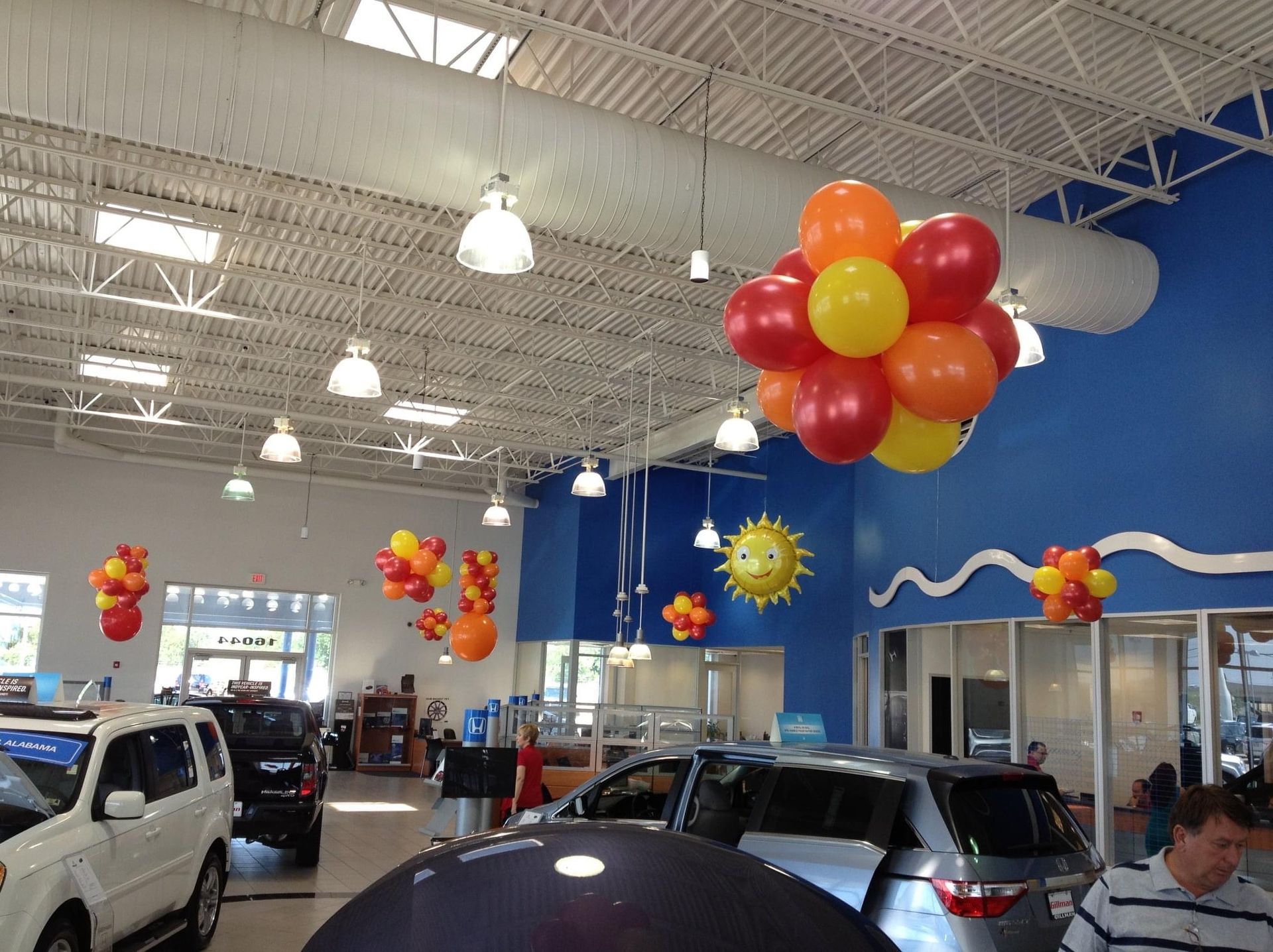 A car dealership with balloons hanging from the ceiling