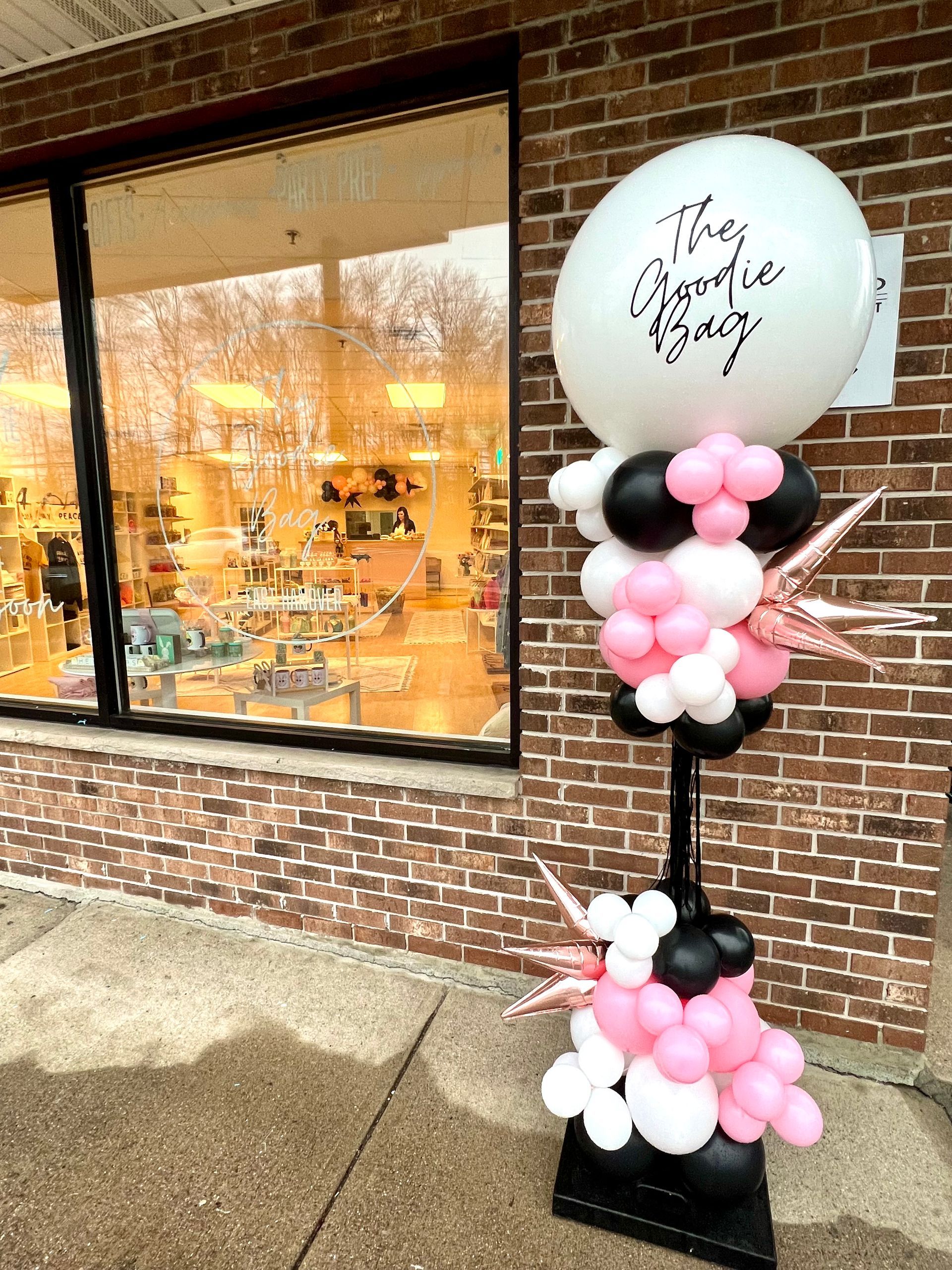 A balloon tower is sitting in front of a brick building.
