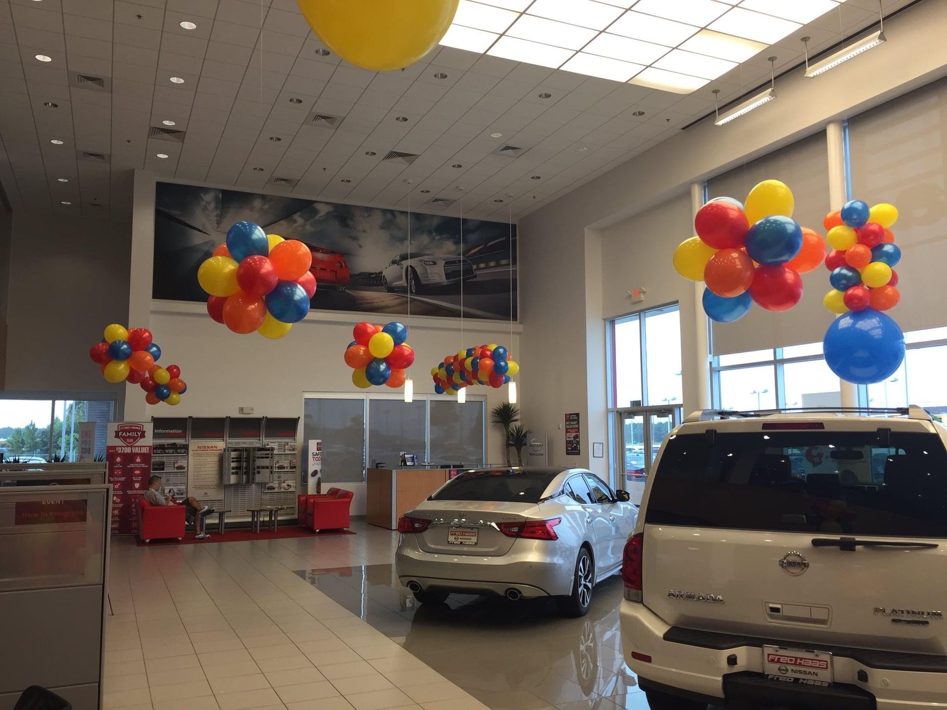 A car dealership with balloons hanging from the ceiling