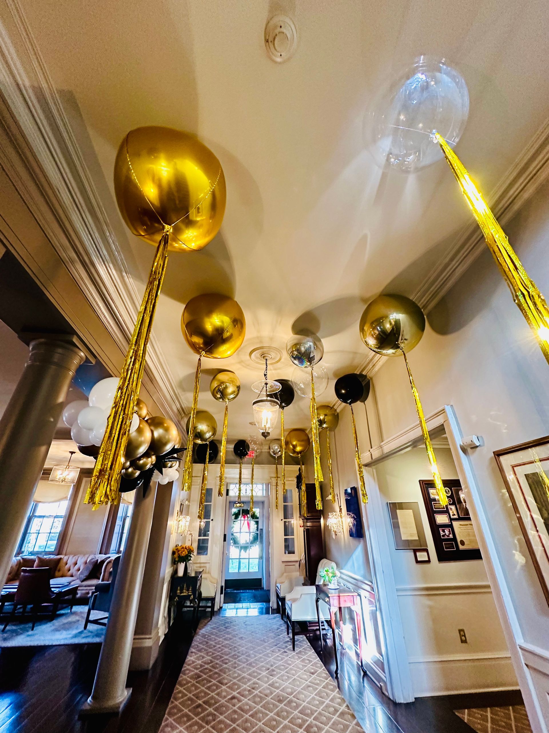 A hallway filled with balloons and streamers hanging from the ceiling.