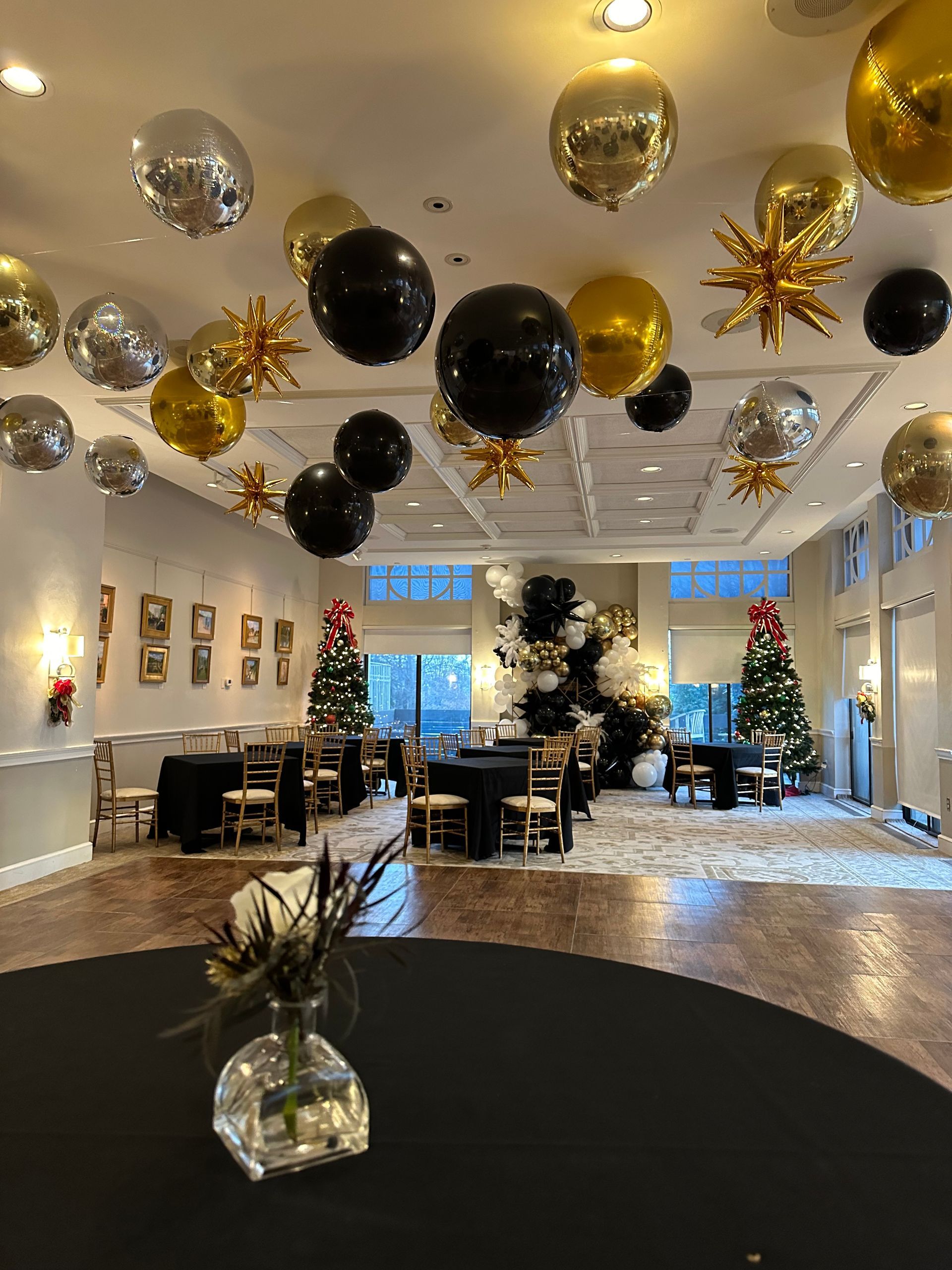 A large room decorated for a party with balloons hanging from the ceiling.