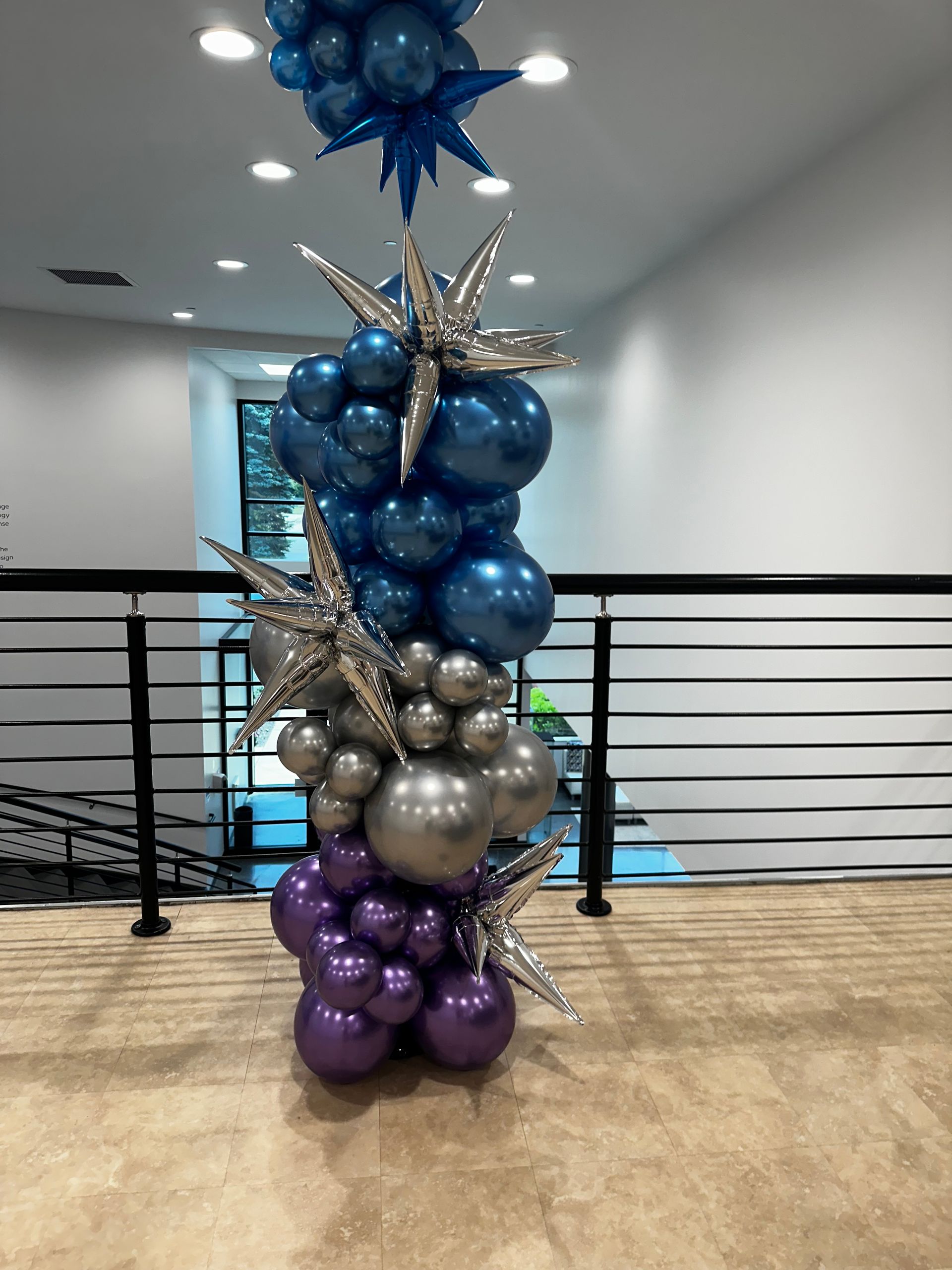 A bunch of balloons are stacked on top of each other in a room.