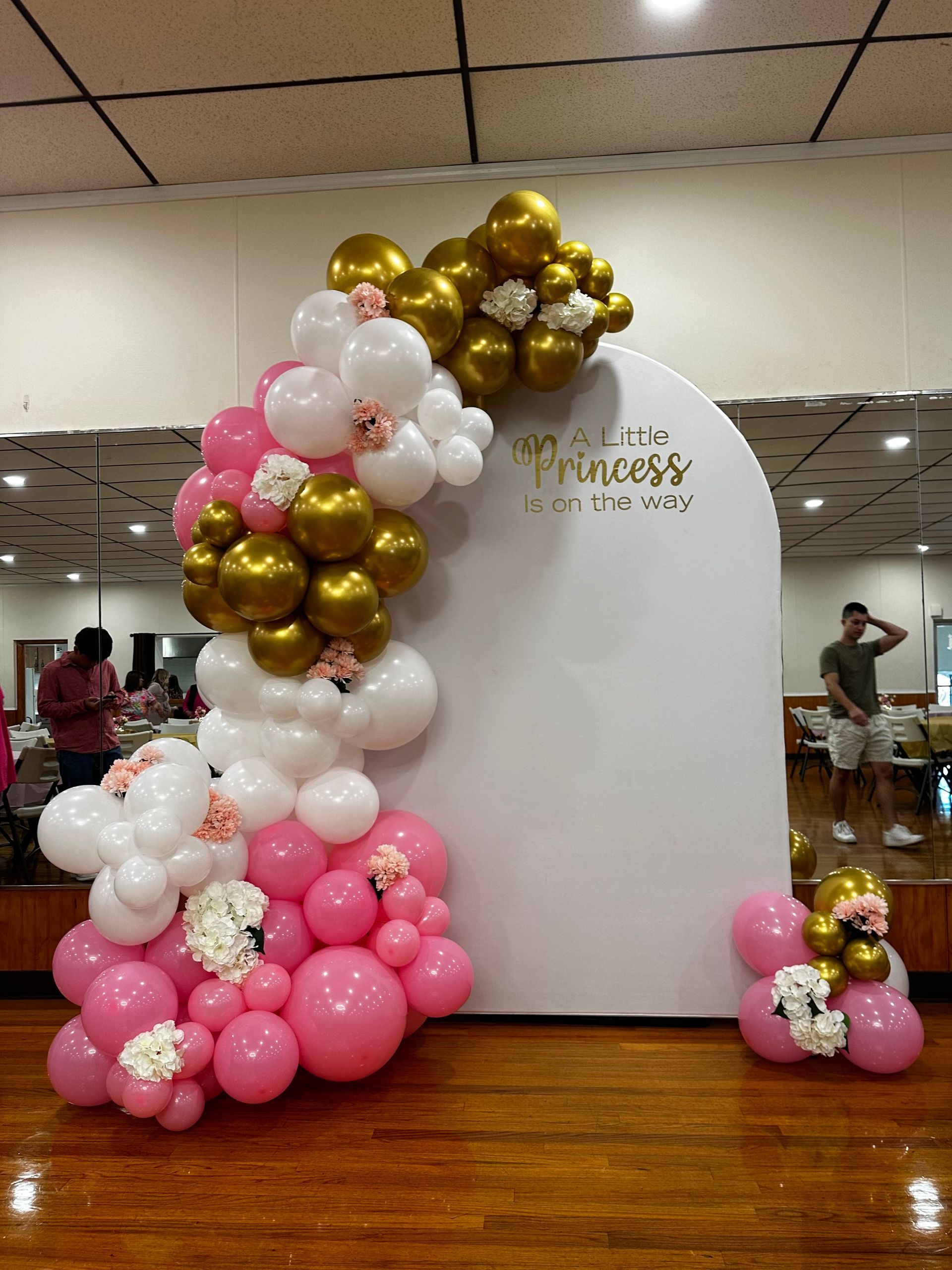 A bunch of pink and gold balloons on a white wall