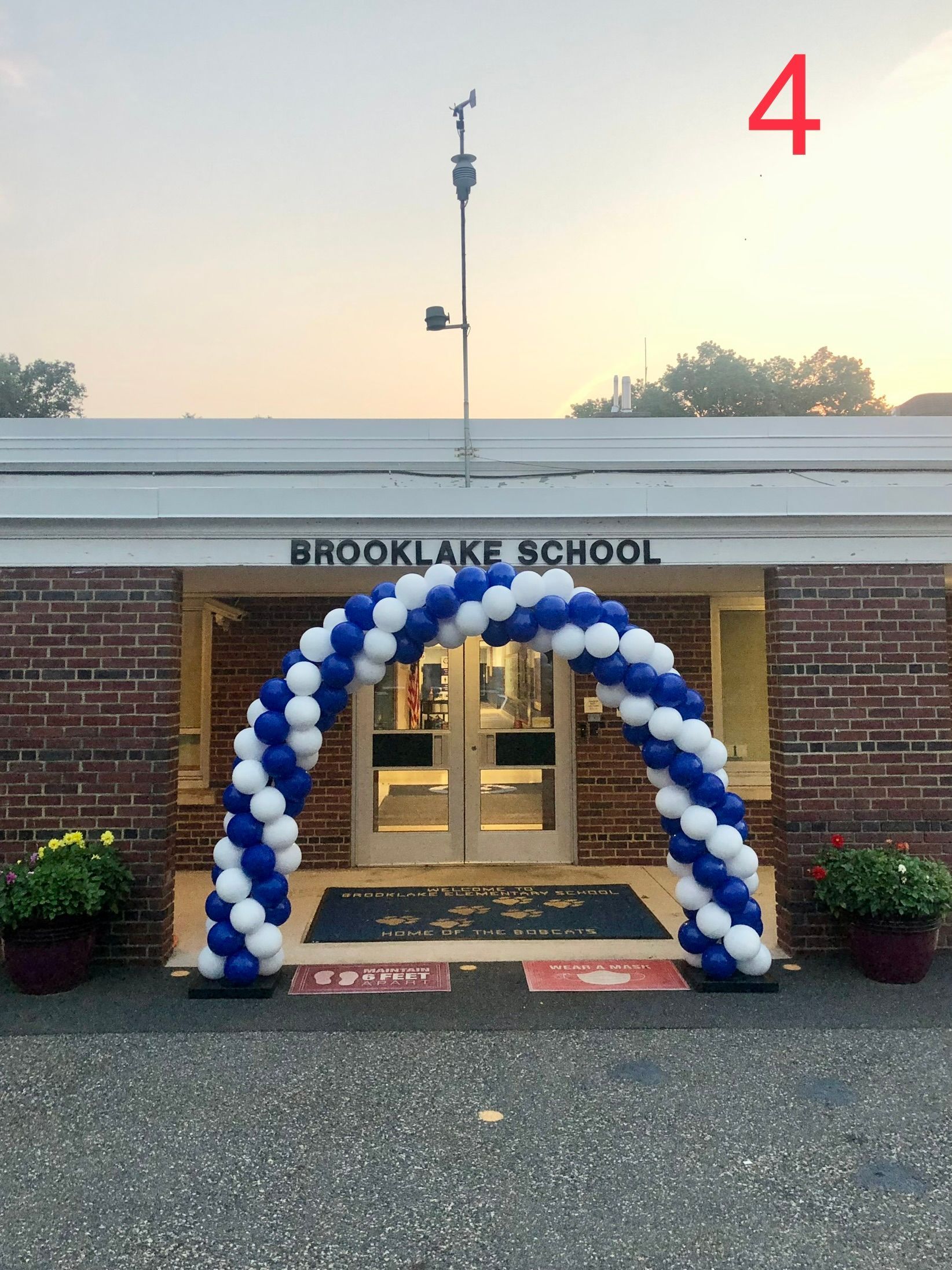A blue and white balloon arch in front of brooklake school