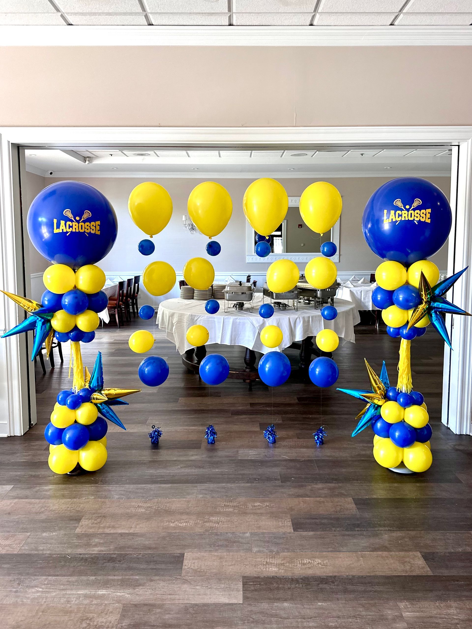 A room is decorated with blue and yellow balloons.