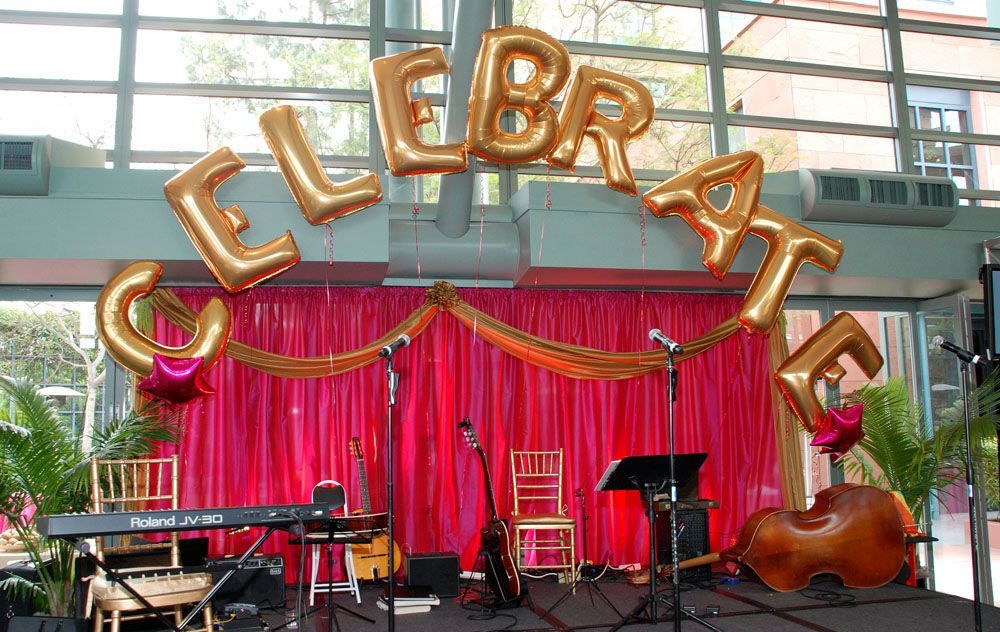 A stage with balloons that say celebrate on it