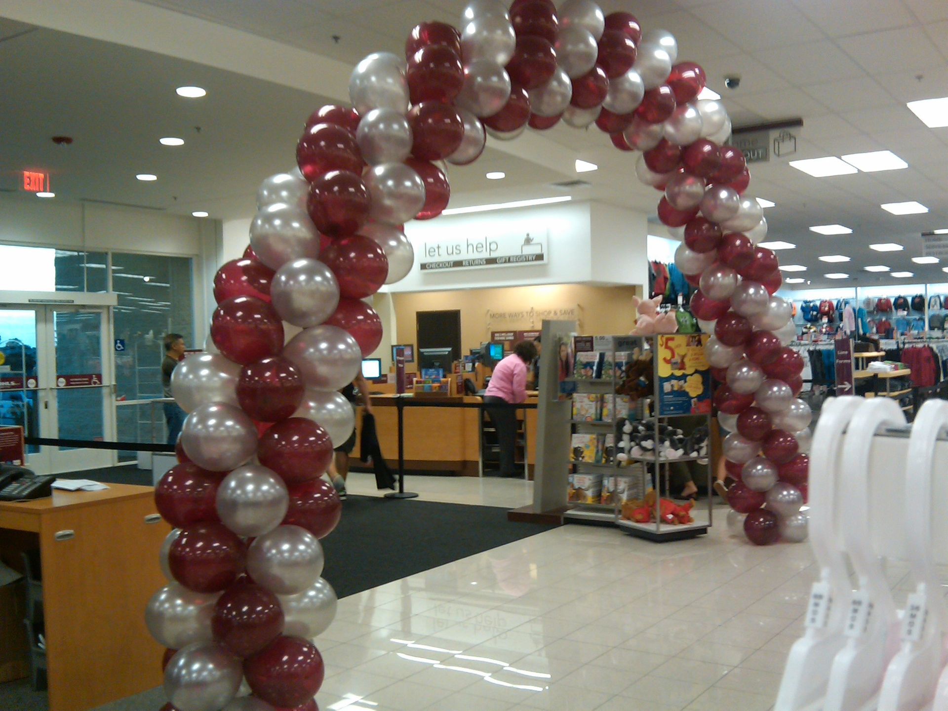 A red and white balloon arch in a store