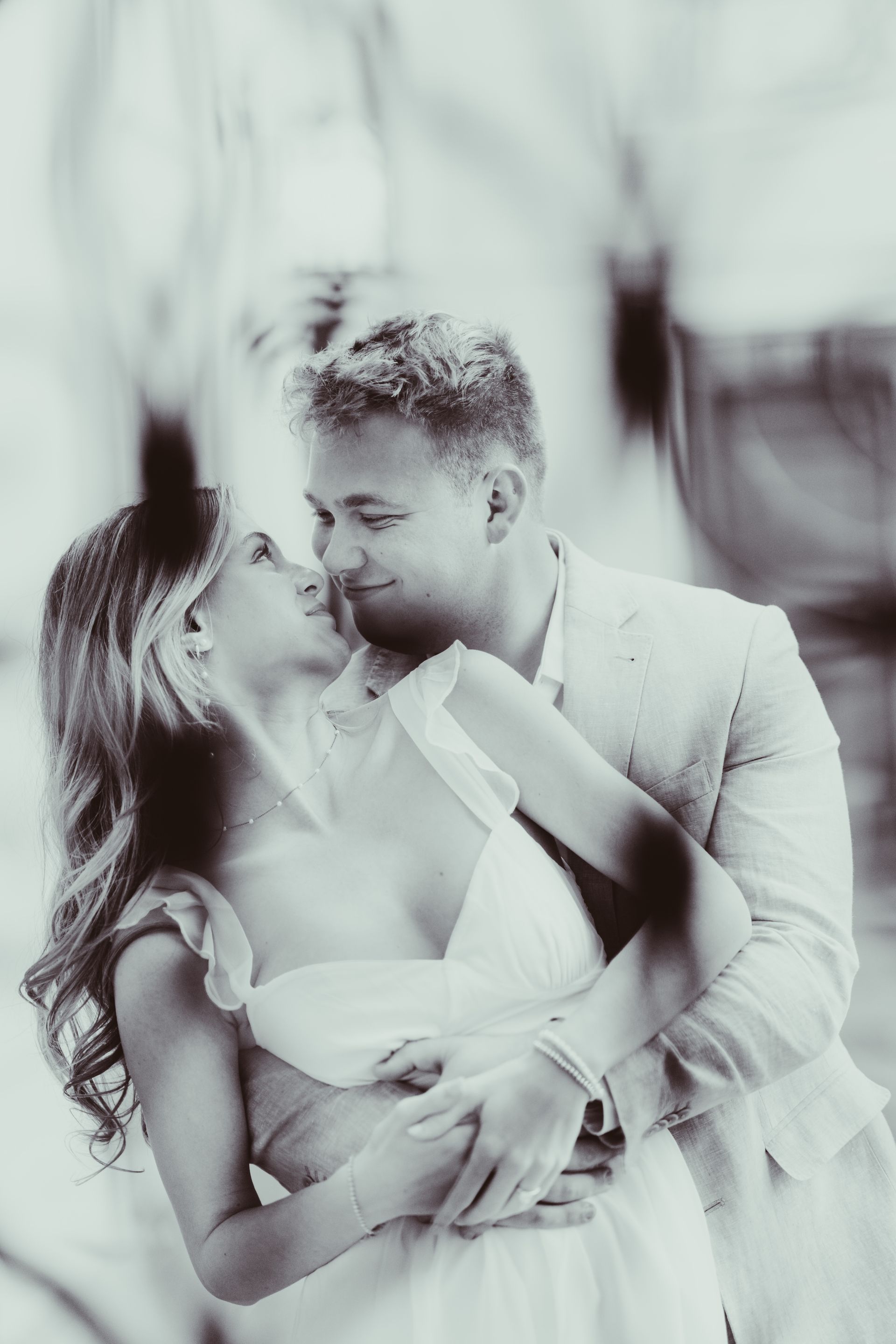 a man and a woman are kissing in a black and white photo .