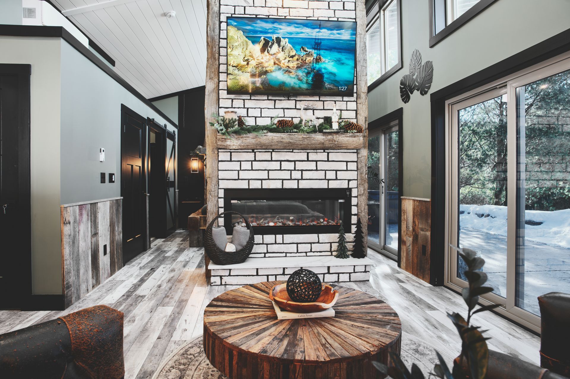 A living room with a fireplace and a flat screen tv on the wall.