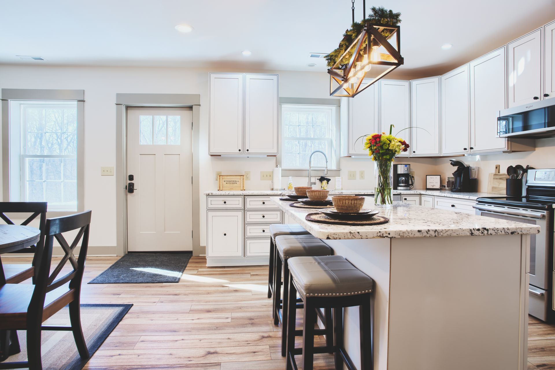 A kitchen with white cabinets and a large island in the middle of the room.