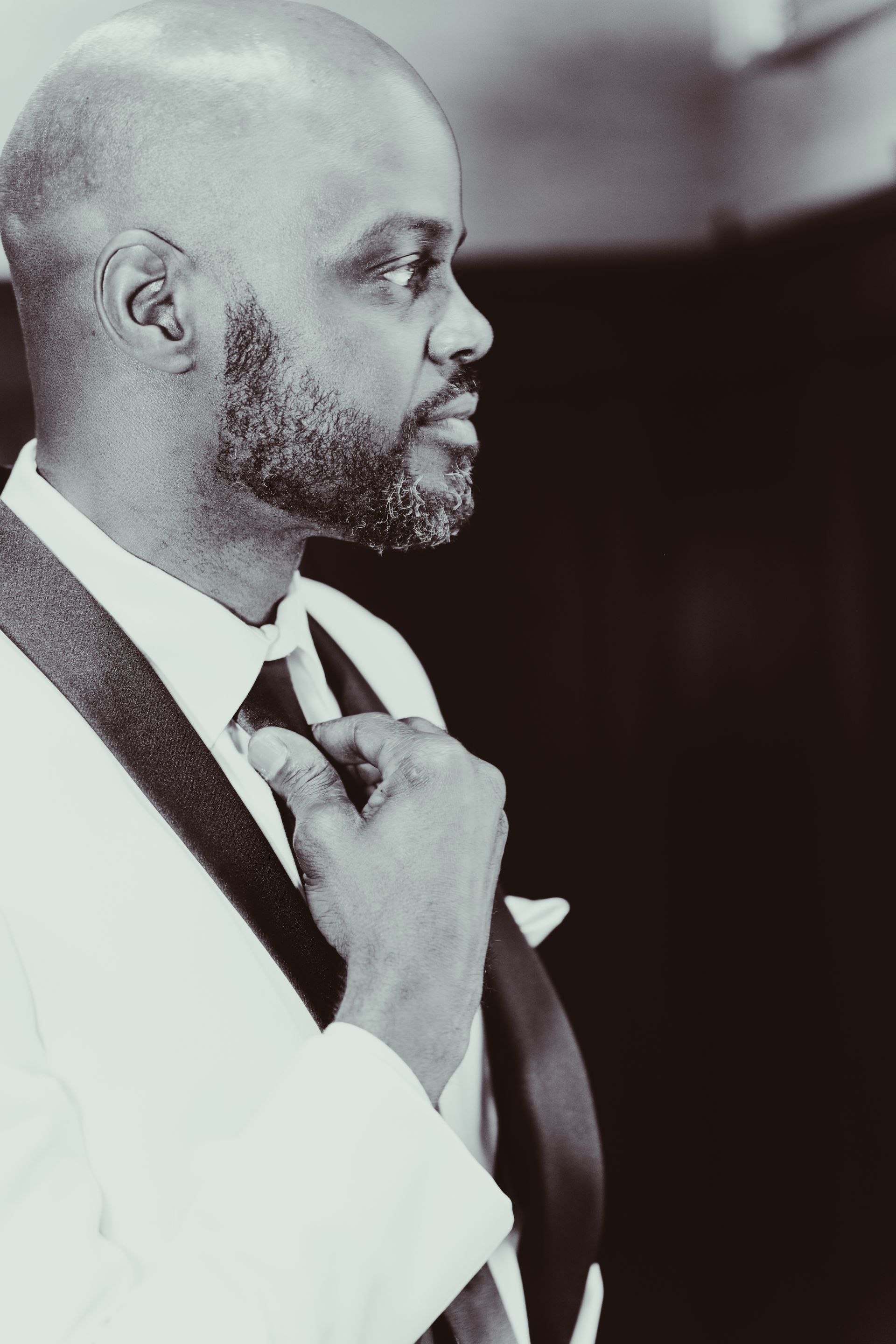 A man in a suit and tie is adjusting his tie