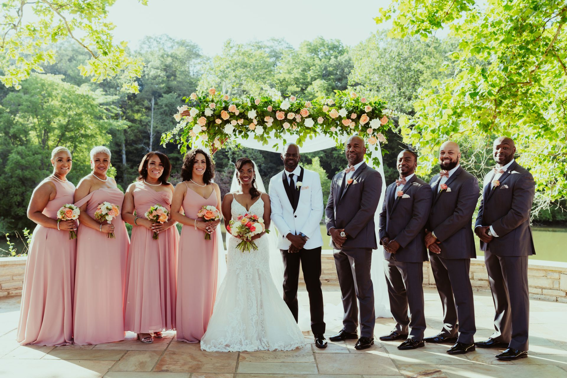 The bride and groom are posing for a picture with their wedding party.