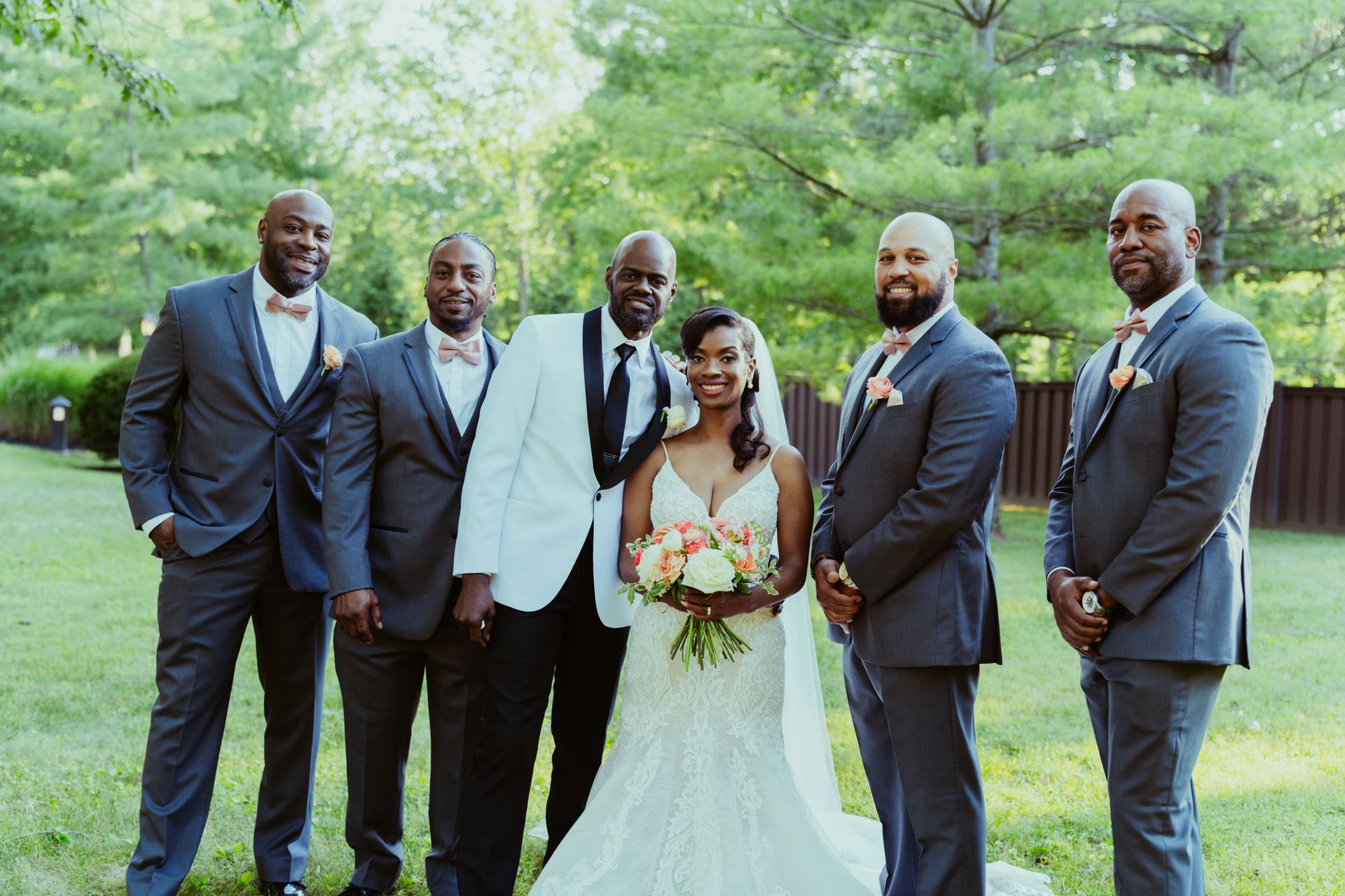 The bride and groom are posing for a picture with their wedding party.