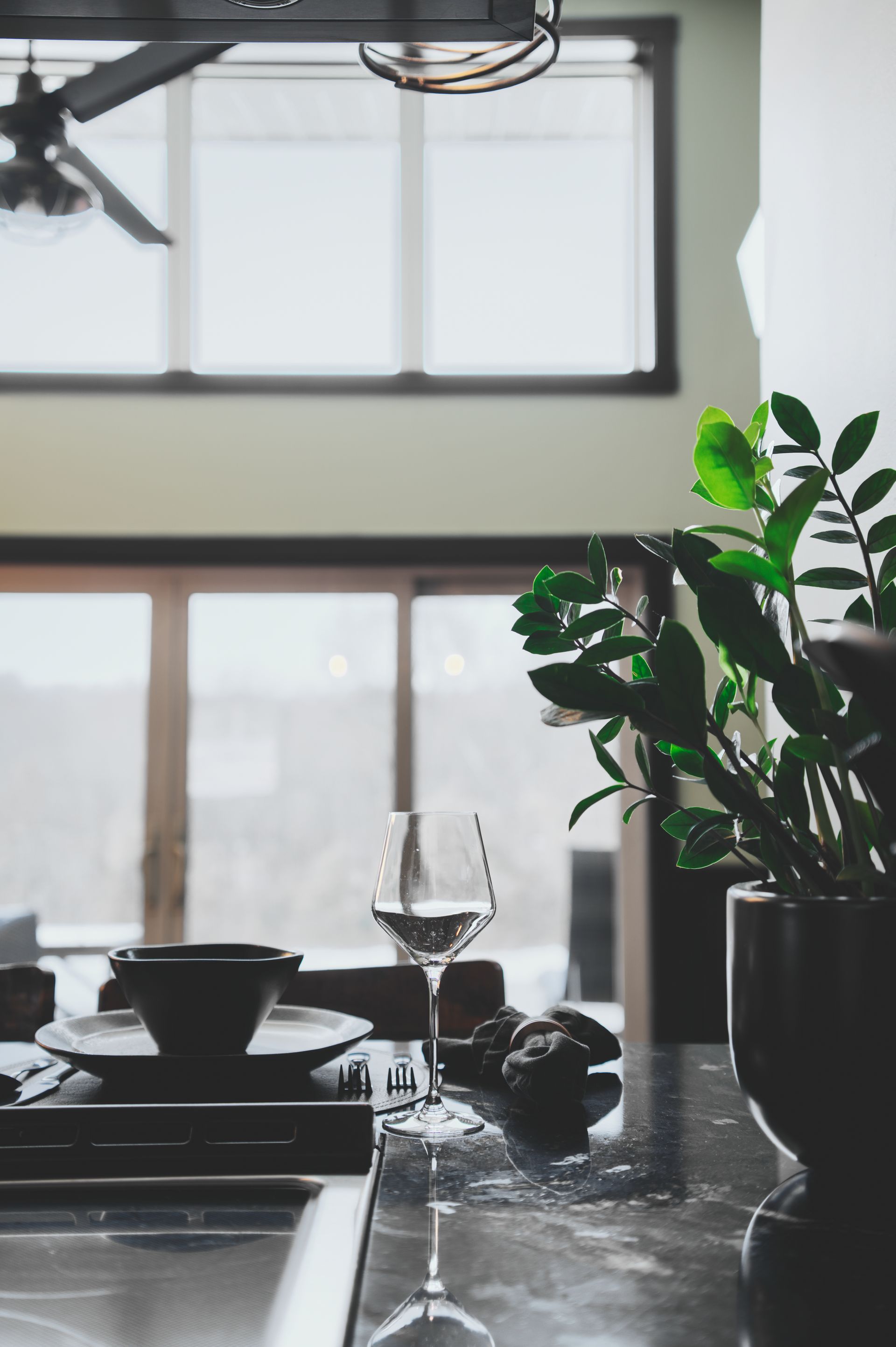 A wine glass is sitting on a counter in a kitchen.