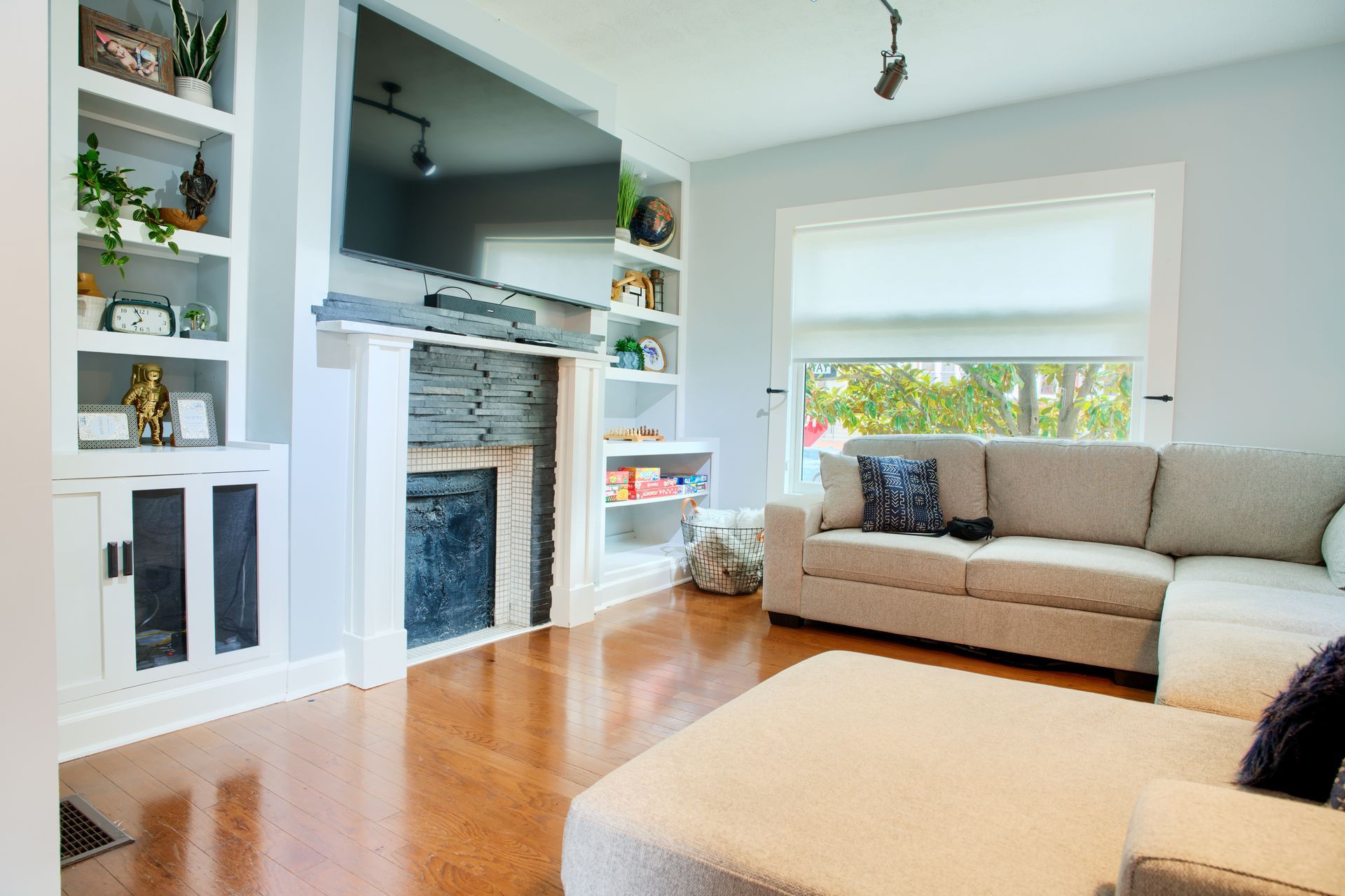 A living room with a couch , fireplace and television.