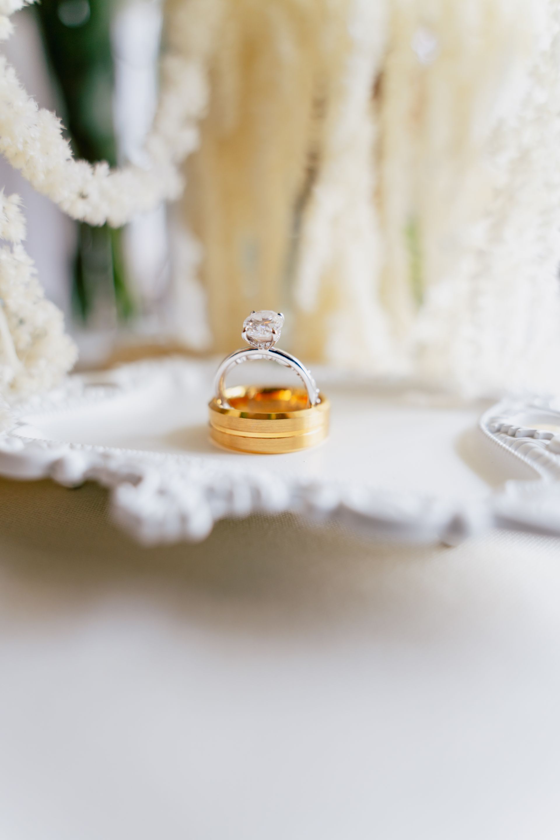 A close up of a wedding ring on a white plate.