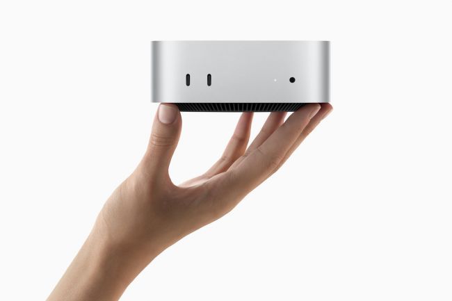 A person is holding a small silver box in their hand.