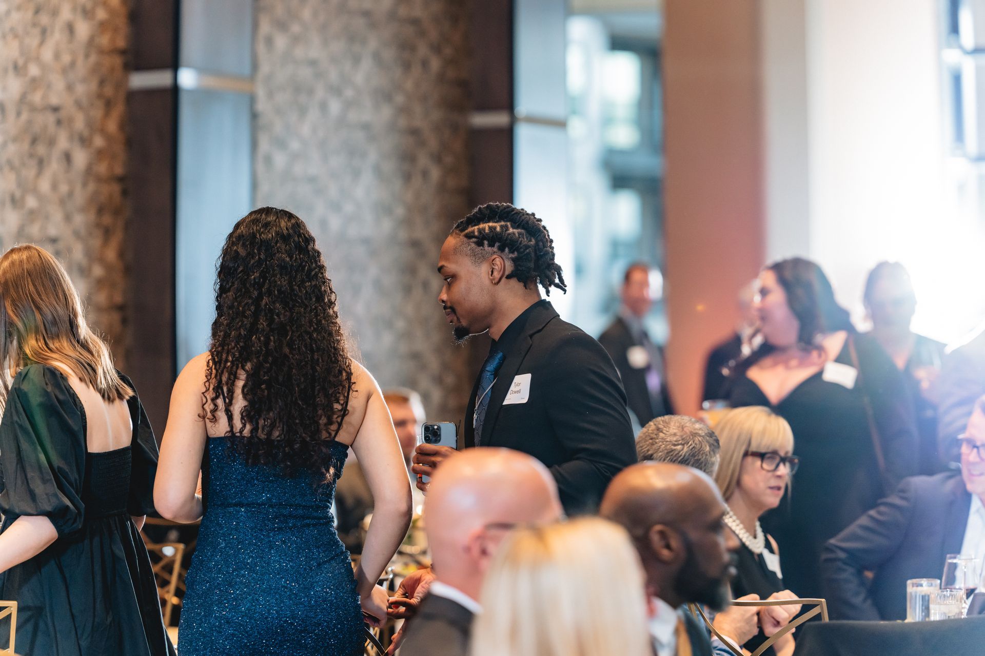 A group of people are standing in a room at a party.