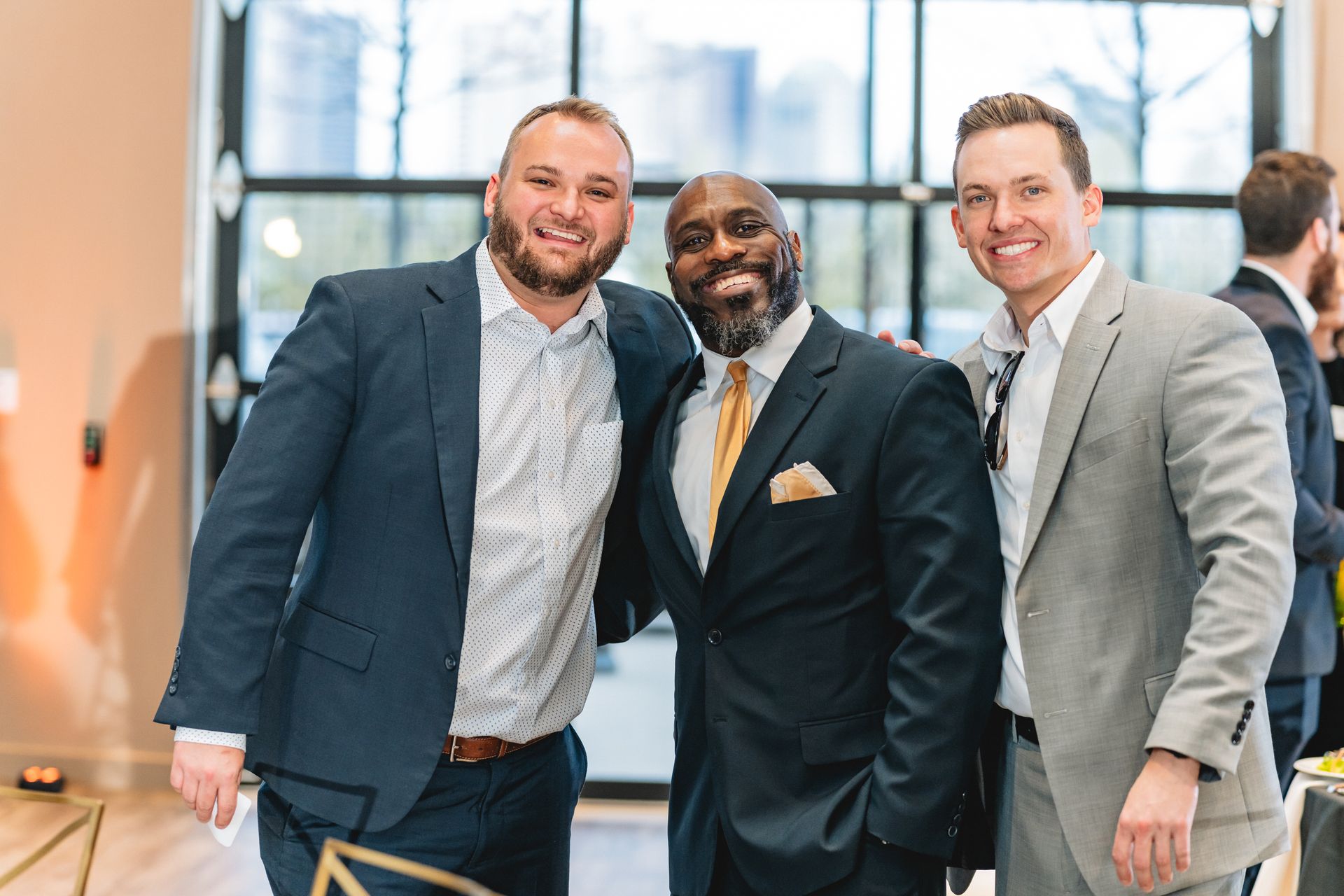 Three men in suits are posing for a picture together.
