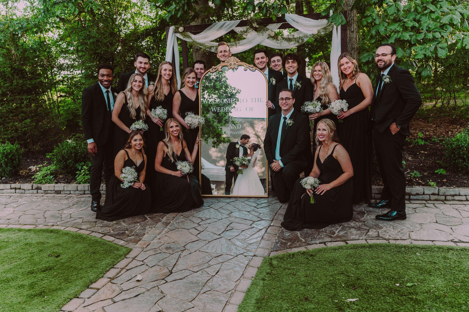 Wedding party posing with a mirror reflecting the bride and groom. 