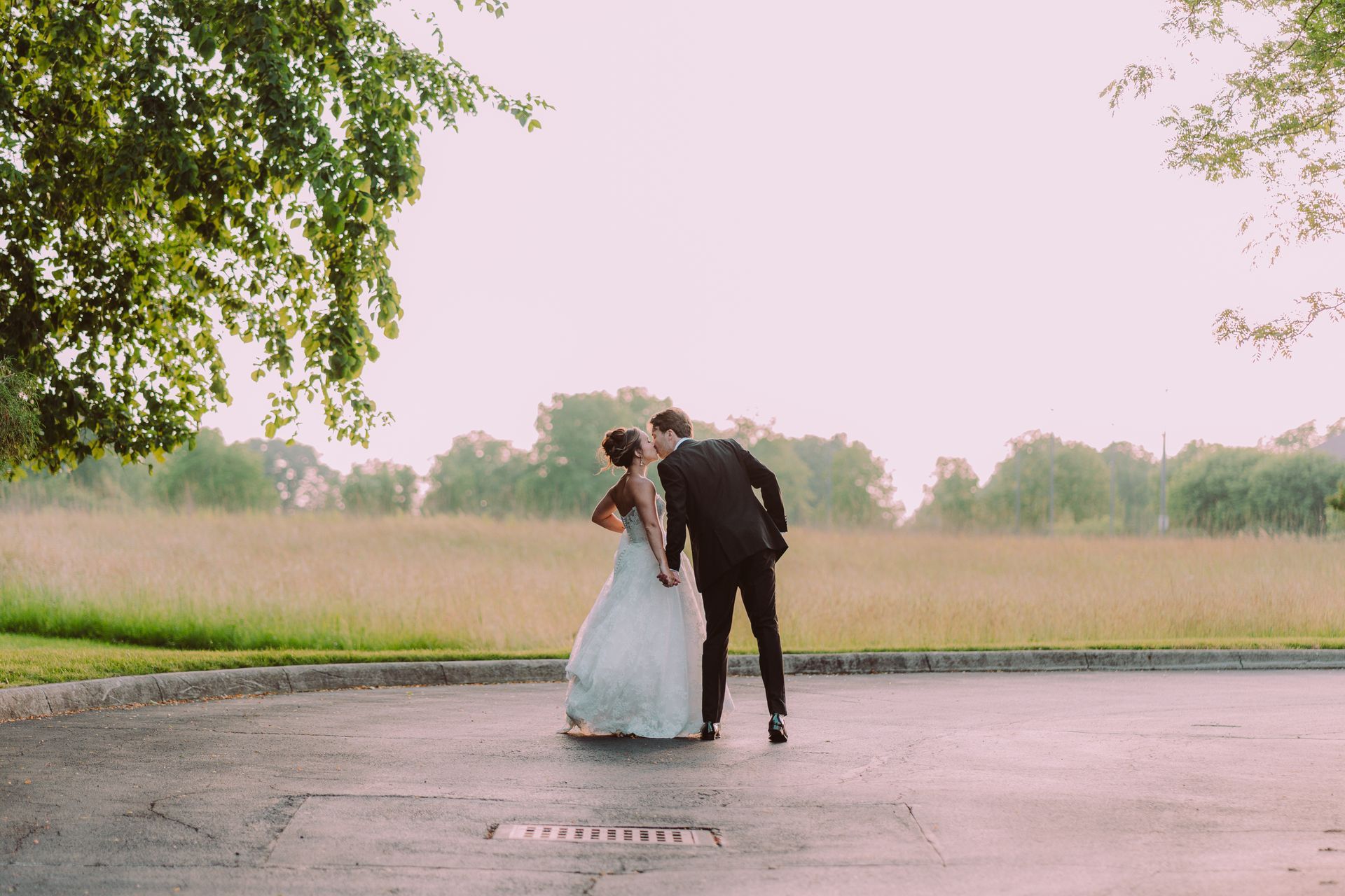 Newlyweds share a kiss outdoors.