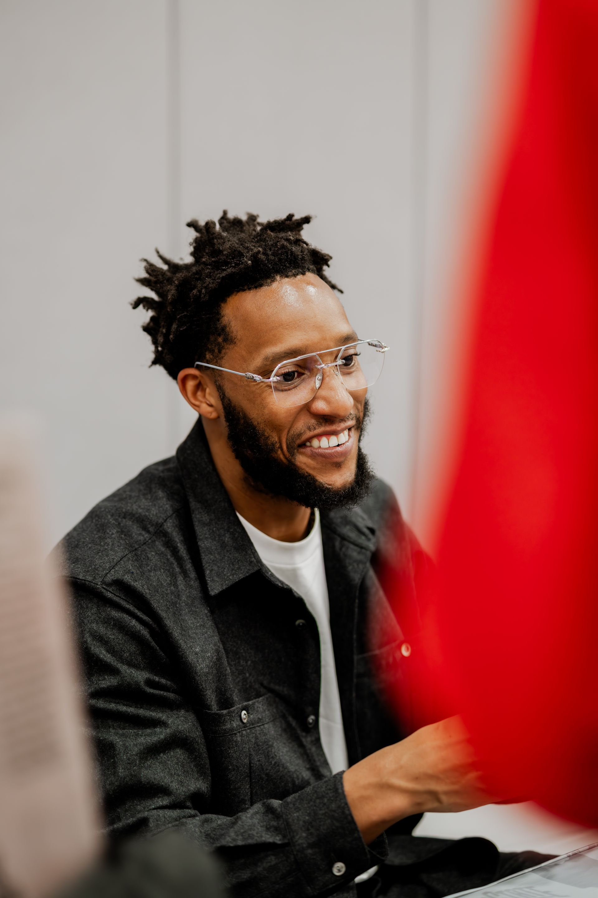 Man wearing glasses smiles, looking to the side.Midwest Cards | Event Photography