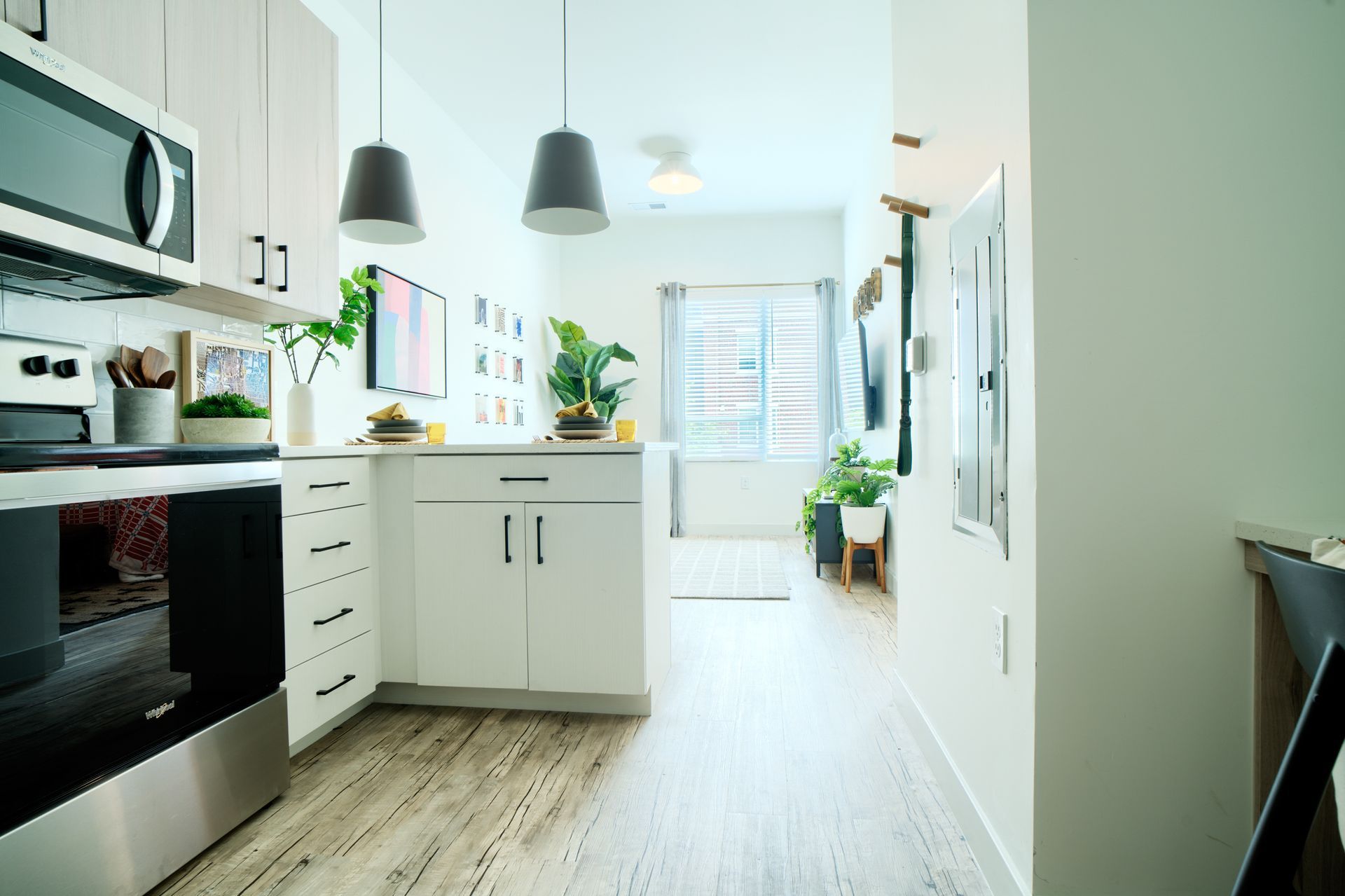 A kitchen with white cabinets , stainless steel appliances , a microwave and a stove.