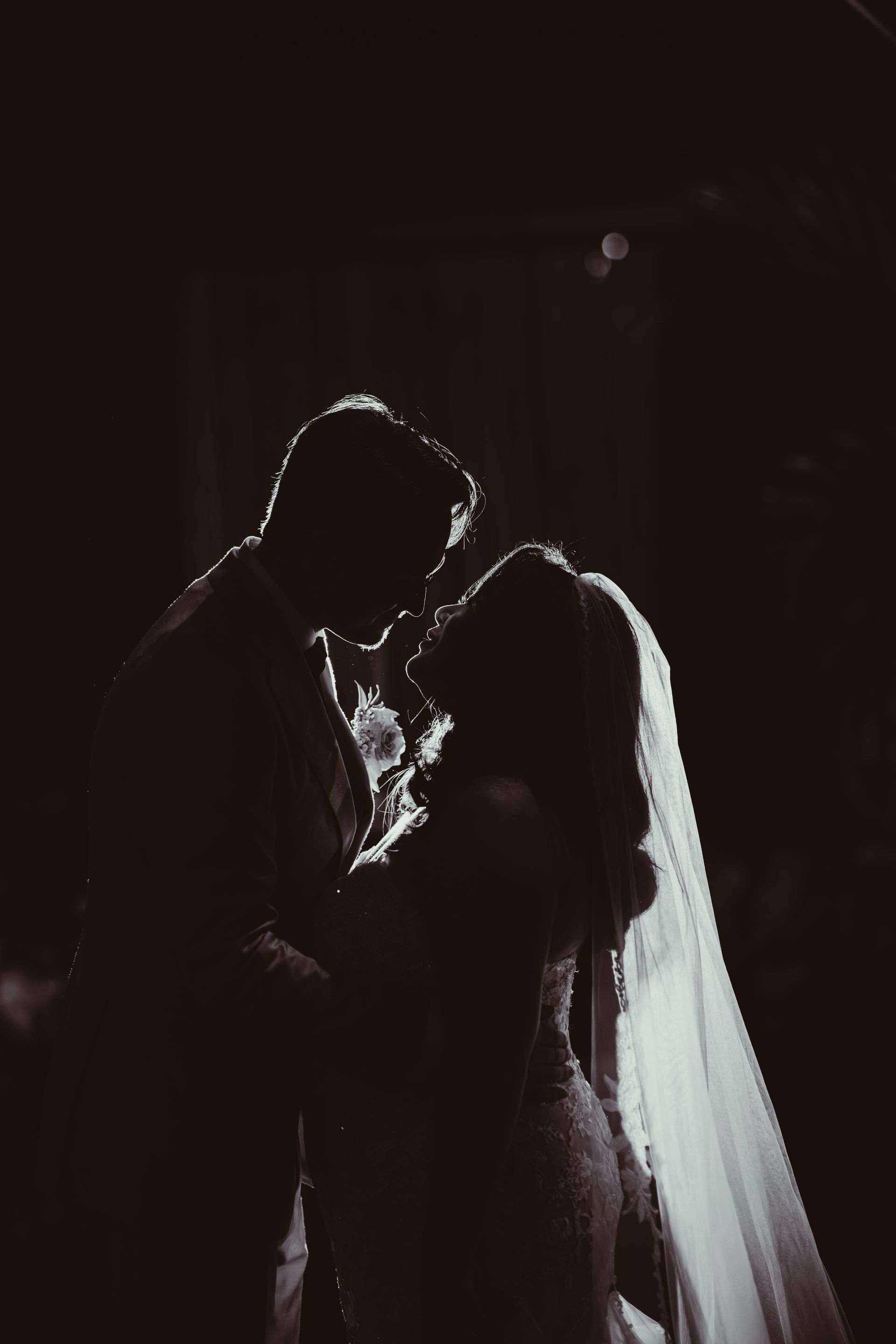 a bride and groom are walking down a path holding hands .
