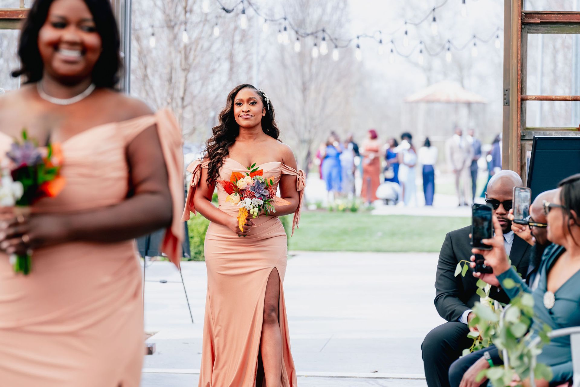 A bride and her bridesmaids are walking down the aisle at a wedding.