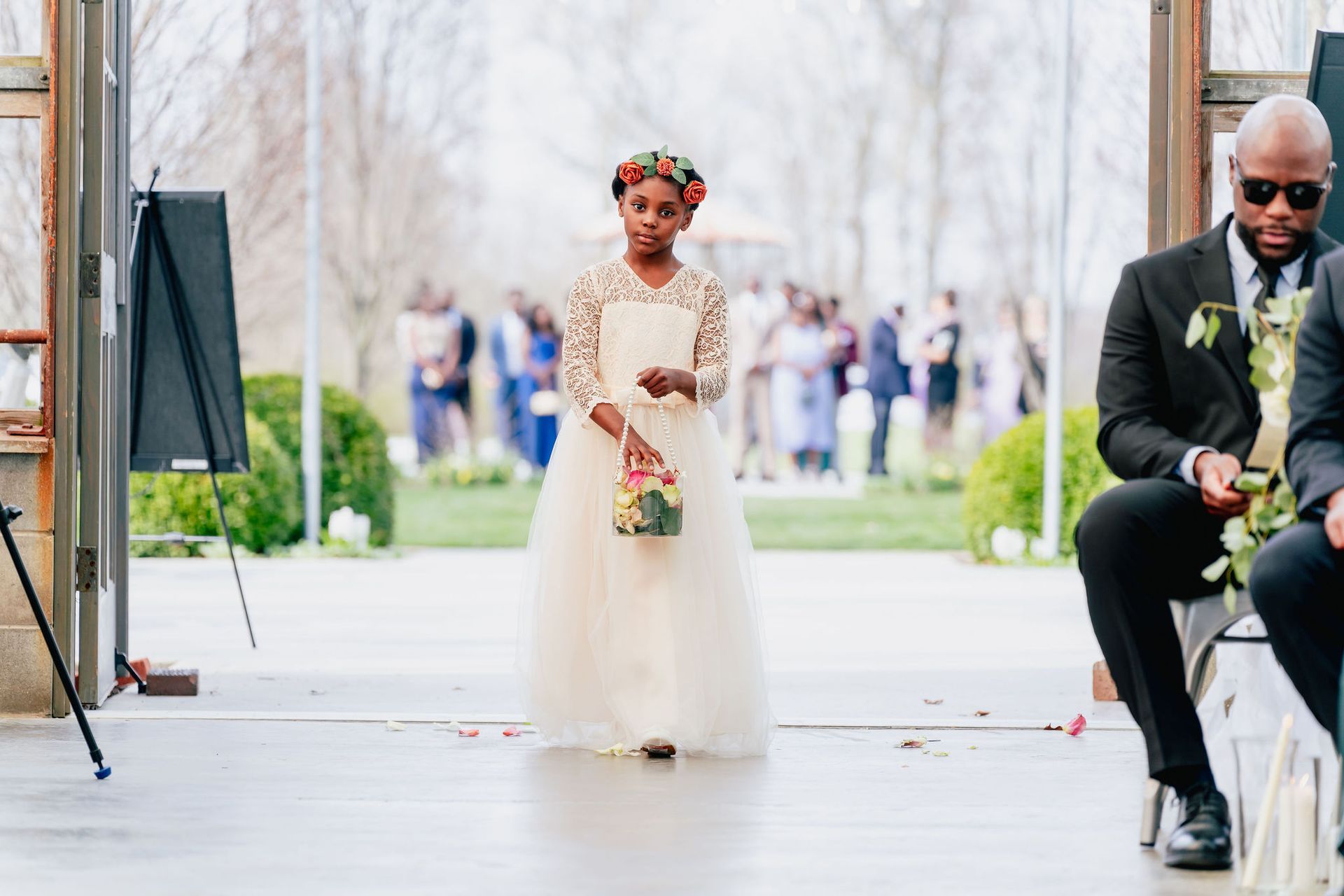 A flower girl is walking down the aisle at a wedding.