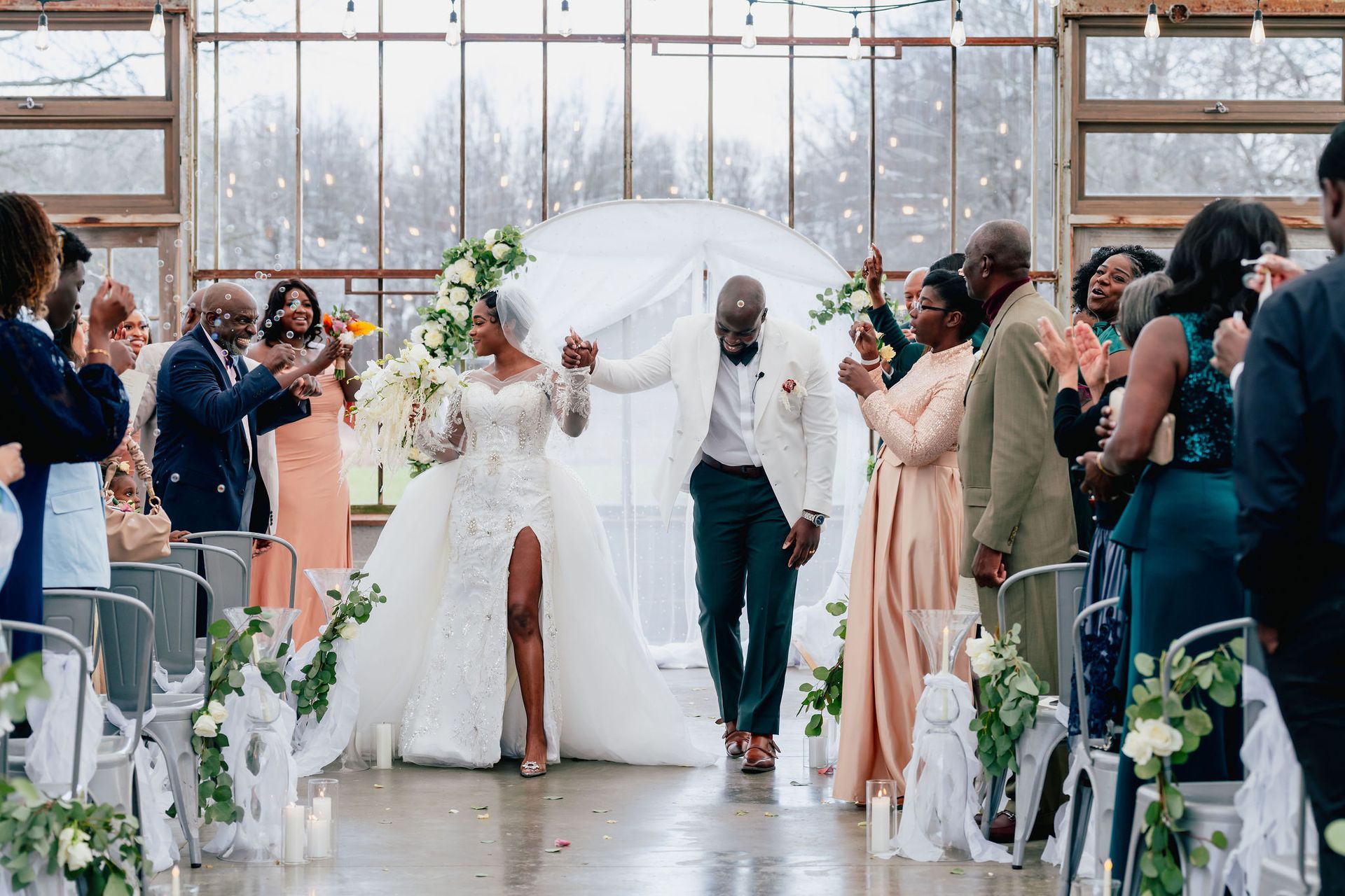 A bride and groom are walking down the aisle at their wedding.
