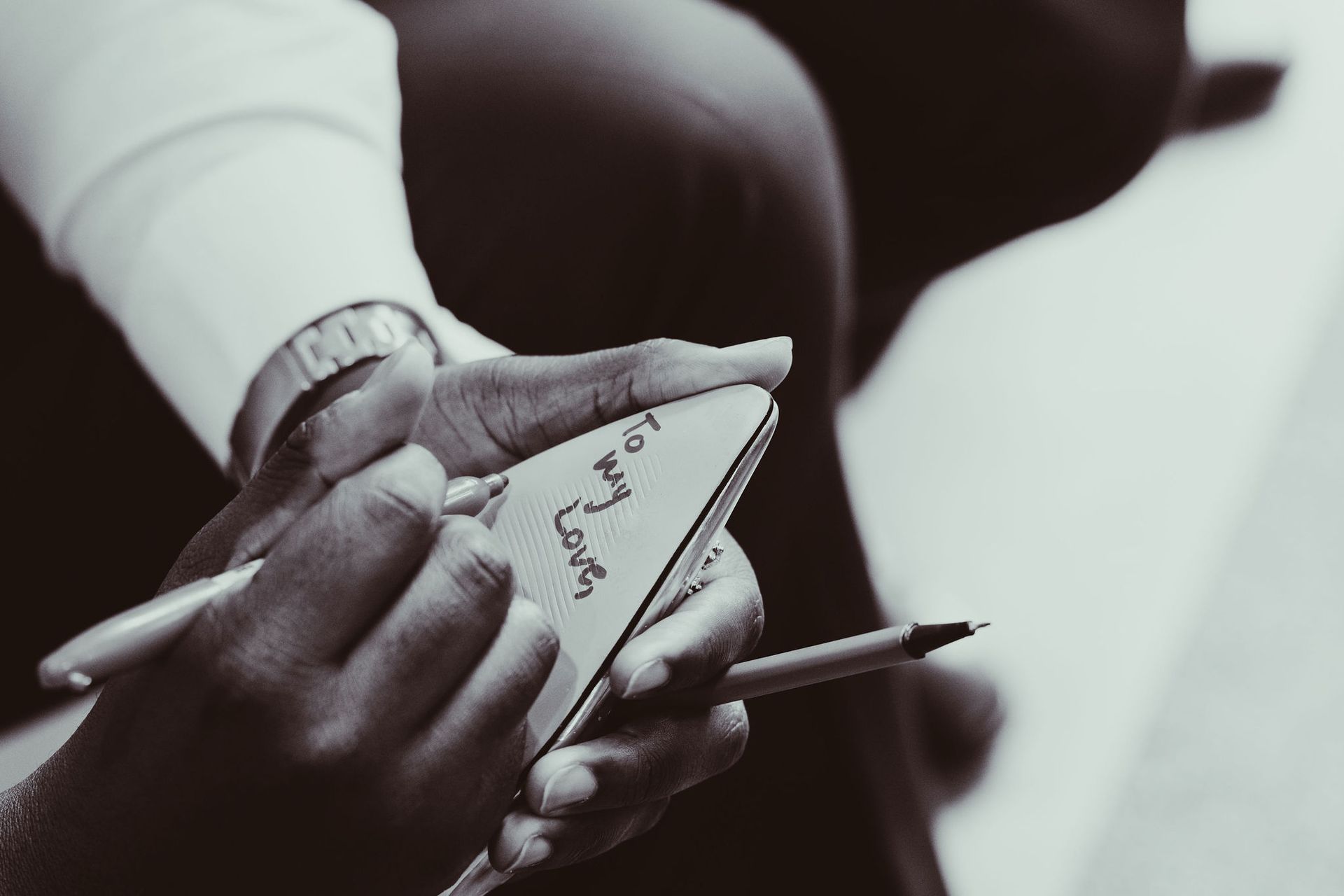 A person is writing on a piece of paper with a pen