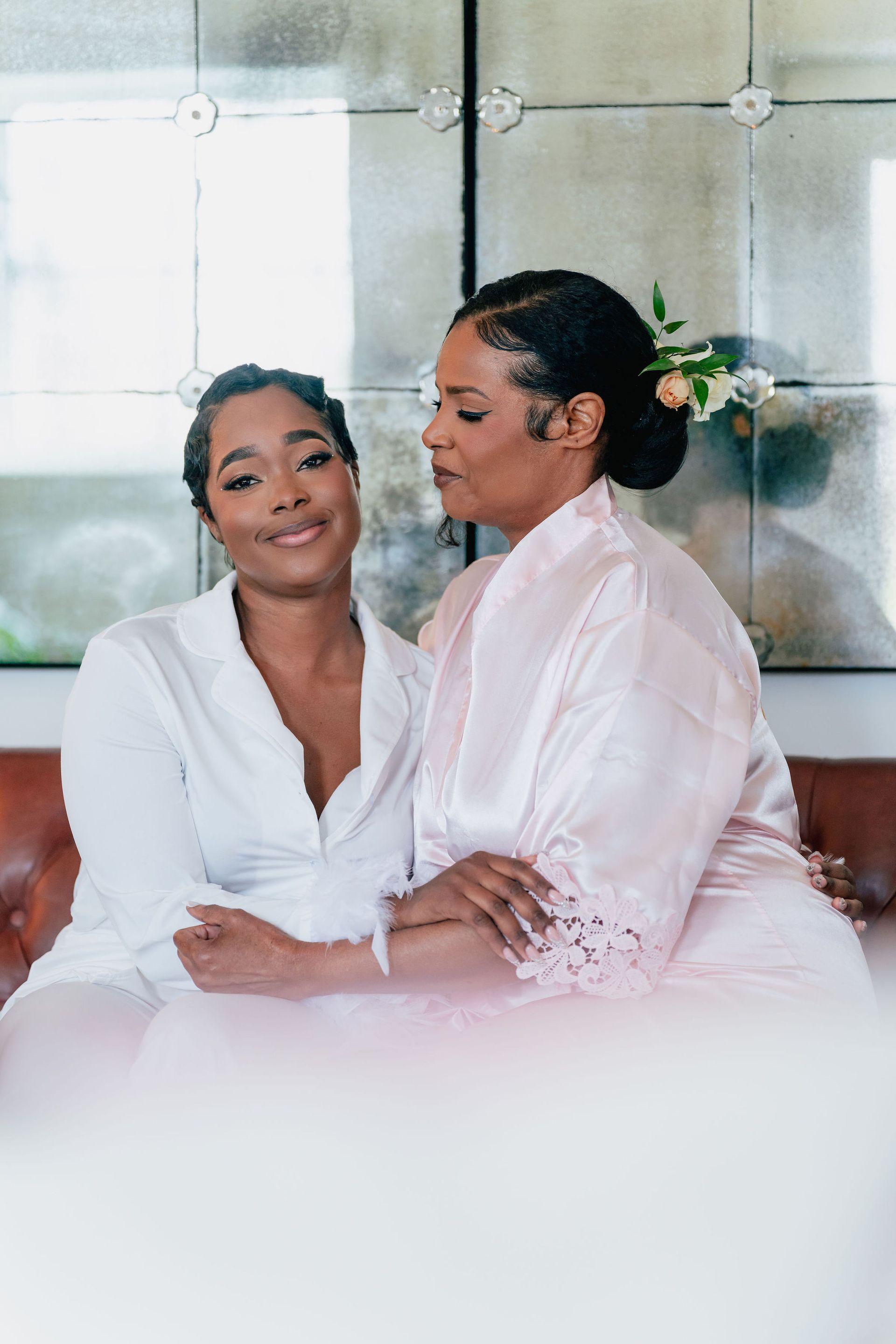Two women are sitting next to each other on a couch.