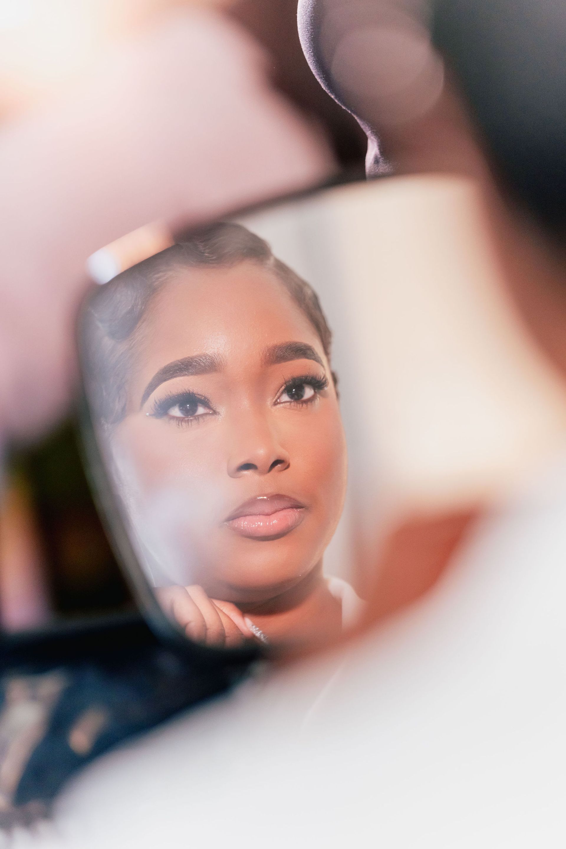 A woman is looking at her reflection in a mirror.