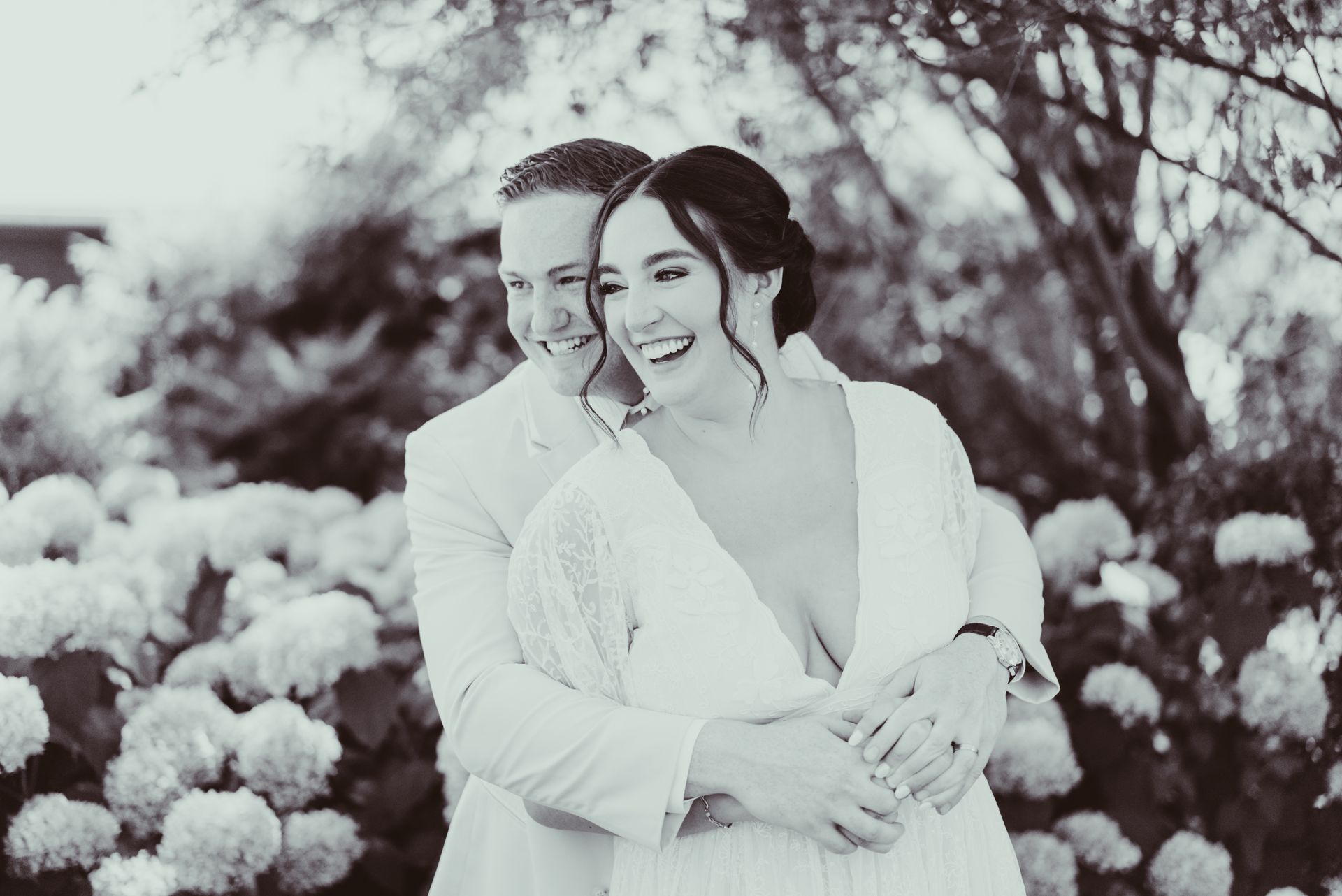 A black and white photo of a bride and groom hugging each other at Jorgensen Oak Grove