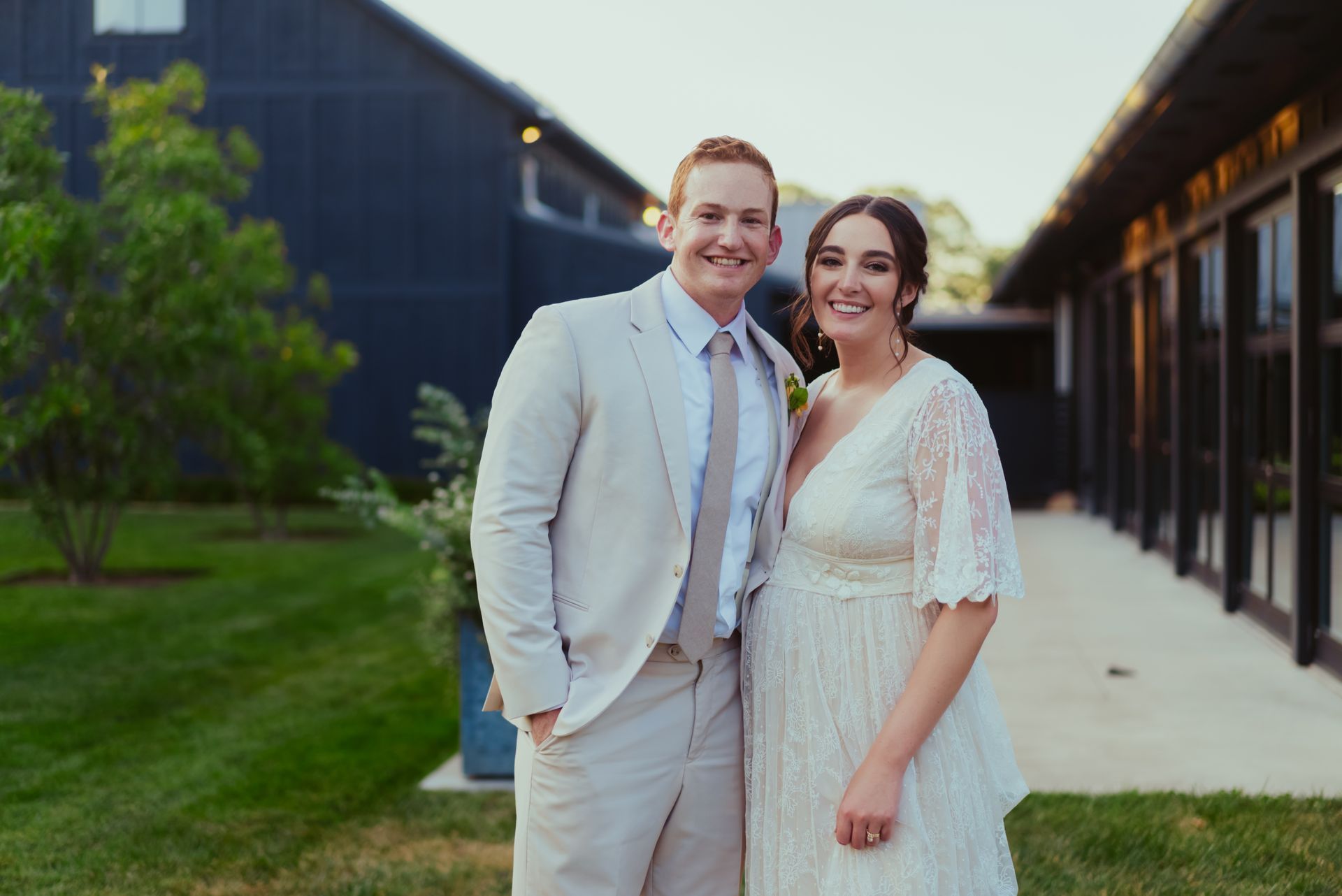 A bride and groom are posing for a picture in front of a building at Jorgensen Oak Grove
